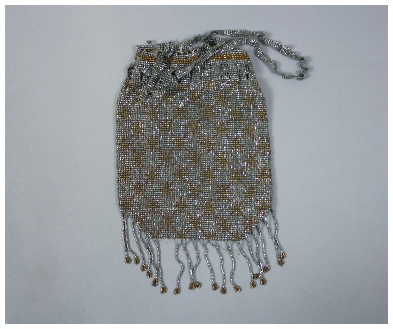 Faceted metal bead purse in silver with copper snowflake design. There is an interwoven bead closure and tassels at the bottom. &nbsp; &nbsp; &nbsp; &nbsp; &nbsp; &nbsp; &nbsp; &nbsp; &nbsp; &nbsp; &nbsp; &nbsp; &nbsp; &nbsp; &nbsp; &nbsp; &nbsp; &n