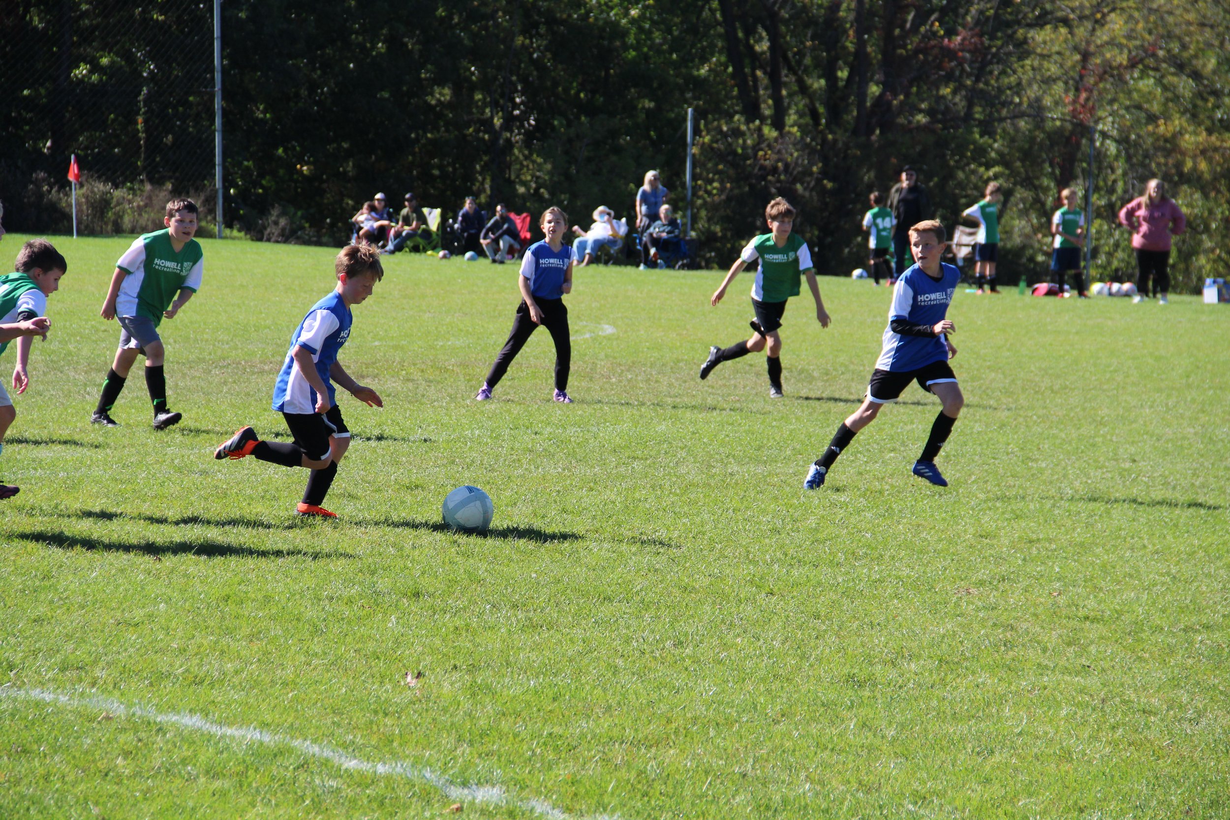 A group of kids play soccer.