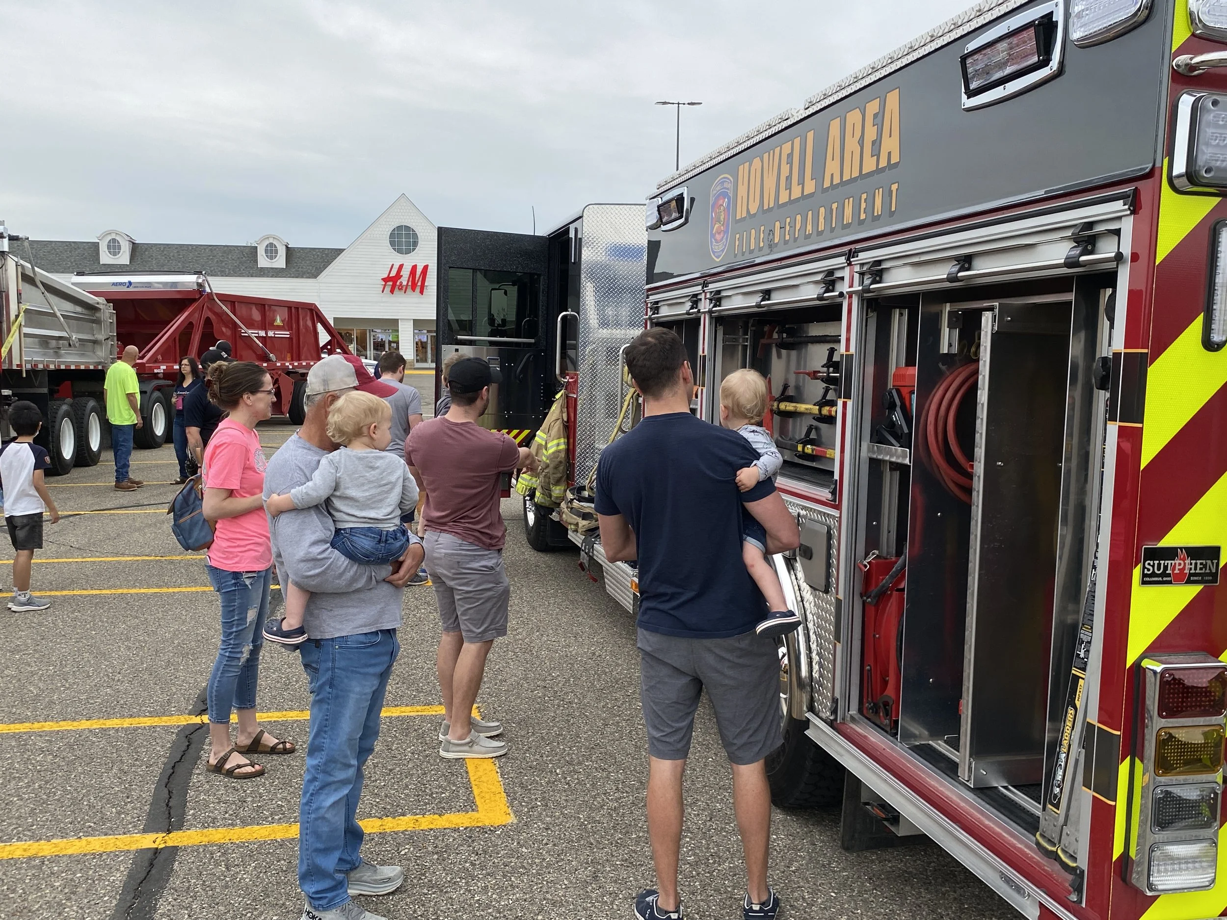 A family checks out a fire truck up close.