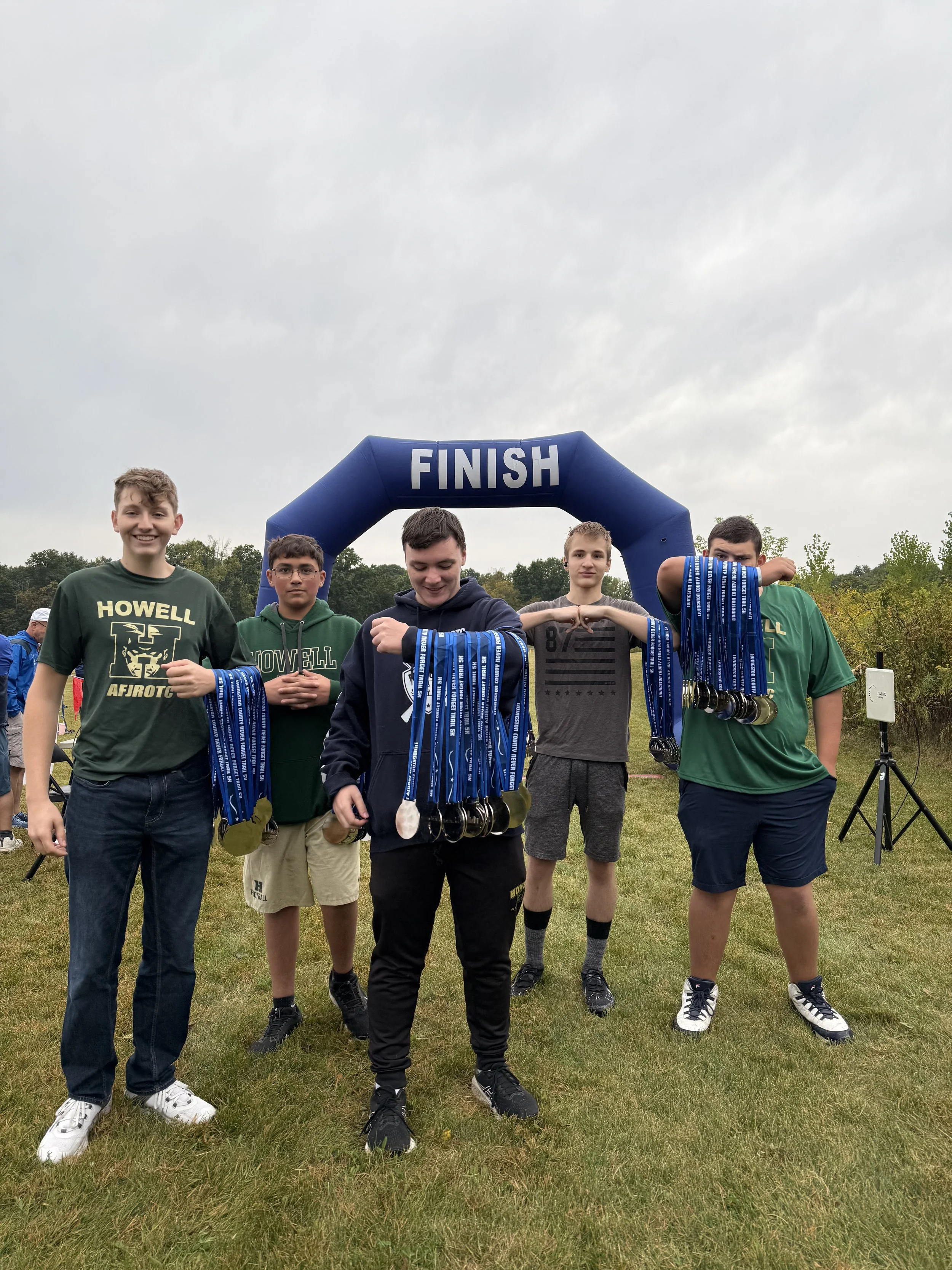 A group of teen volunteers hand out medals at the Never Forget Trail 5K.