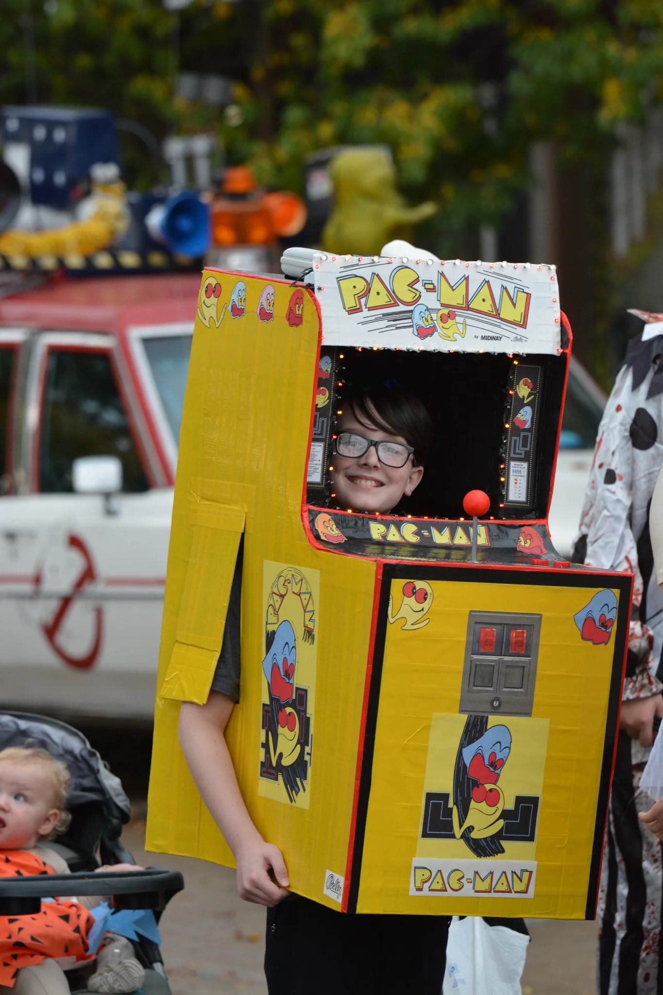A photo of a boy dressed up as a pac-man arcade machine.
