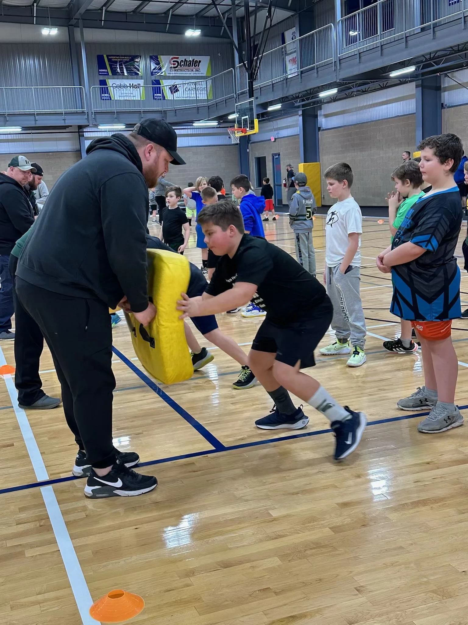 Boys line up to tackle a blocking bag at a GRIT camp.