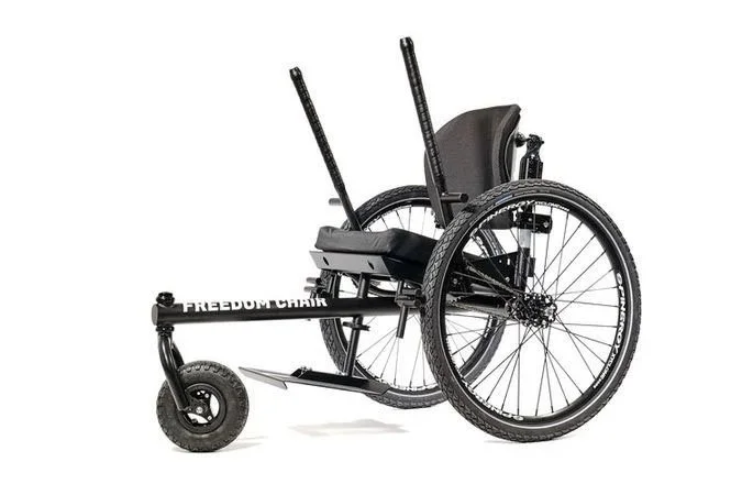 A picture of the GRIT all terrain wheelchair.  A third wheel extends out towards the front and two levers help the user propel themselves forwards.
