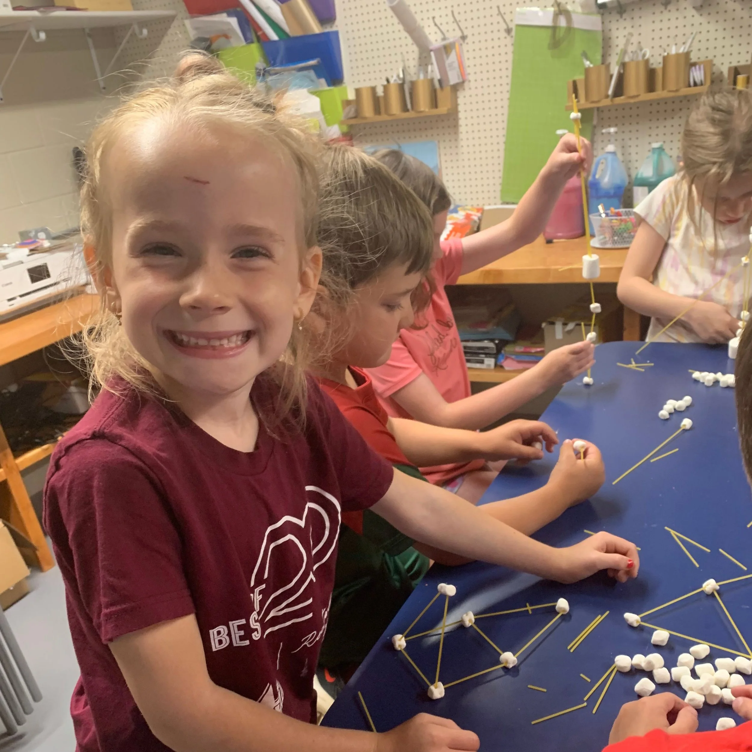 A group of kids build a construction bridge out of pasta and marshmallows.