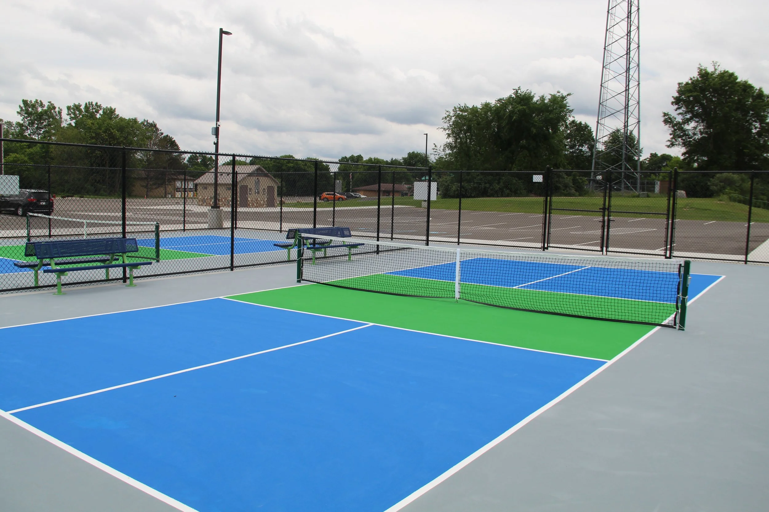 A photo of two blue and green pickleball courts are lined for use outdoors behind the Oceola Community Center.