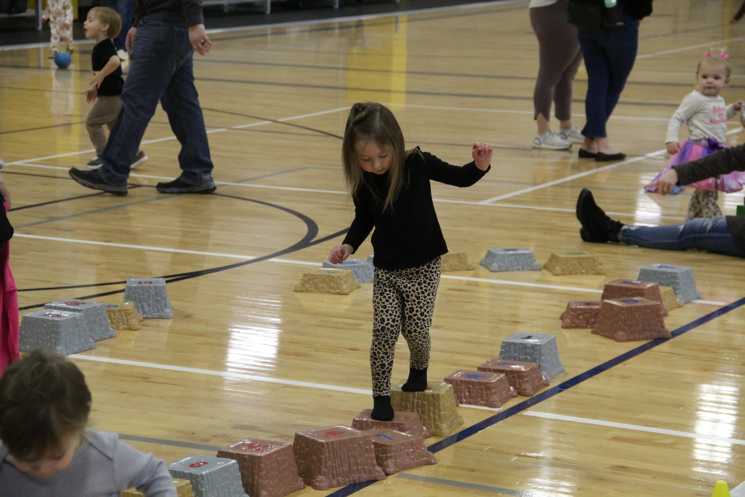 A young girl balances on blocks at a Tot Time event.