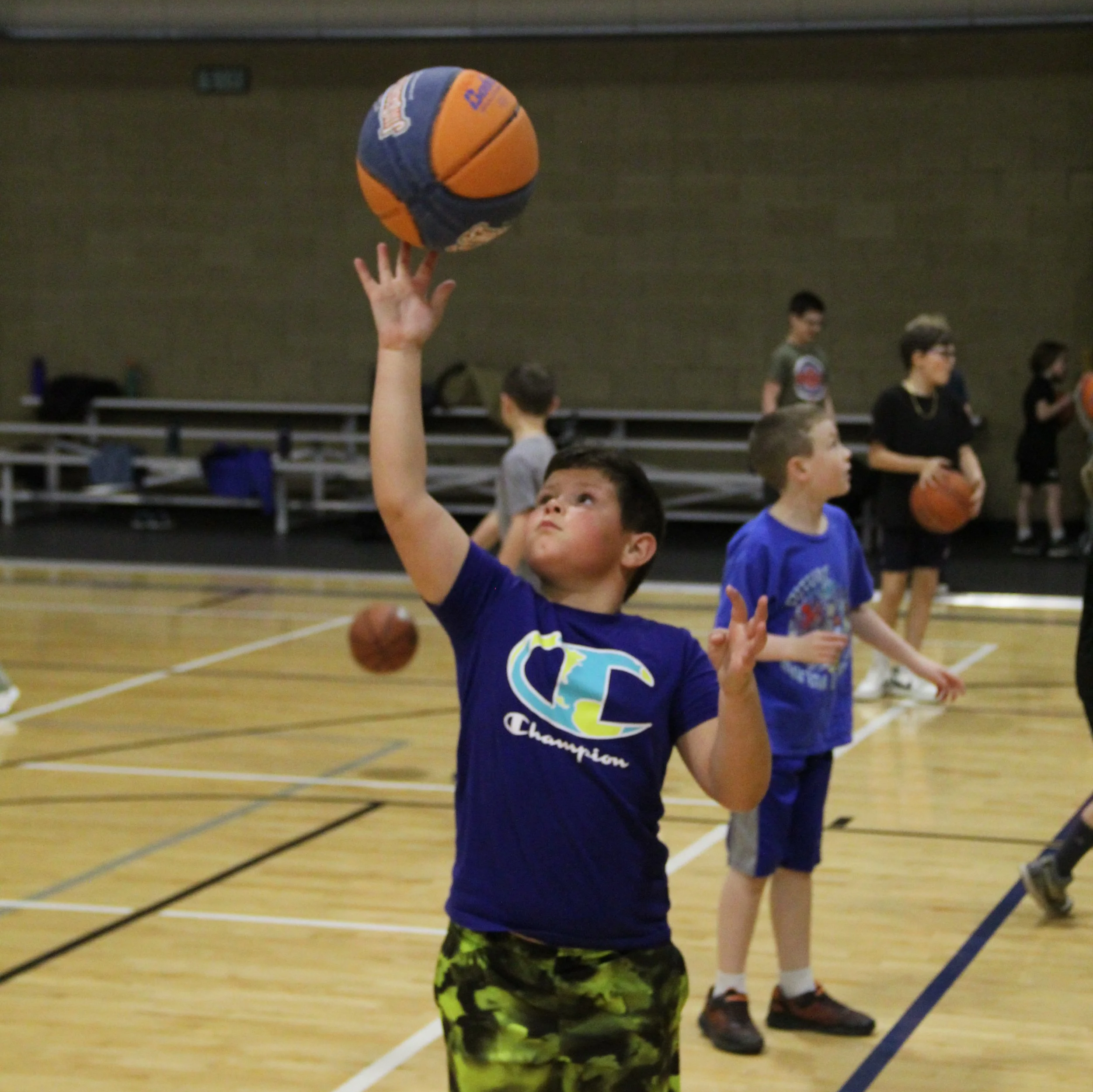 A boy catches a basketball at the 2025 Spring Break Sports Camp.