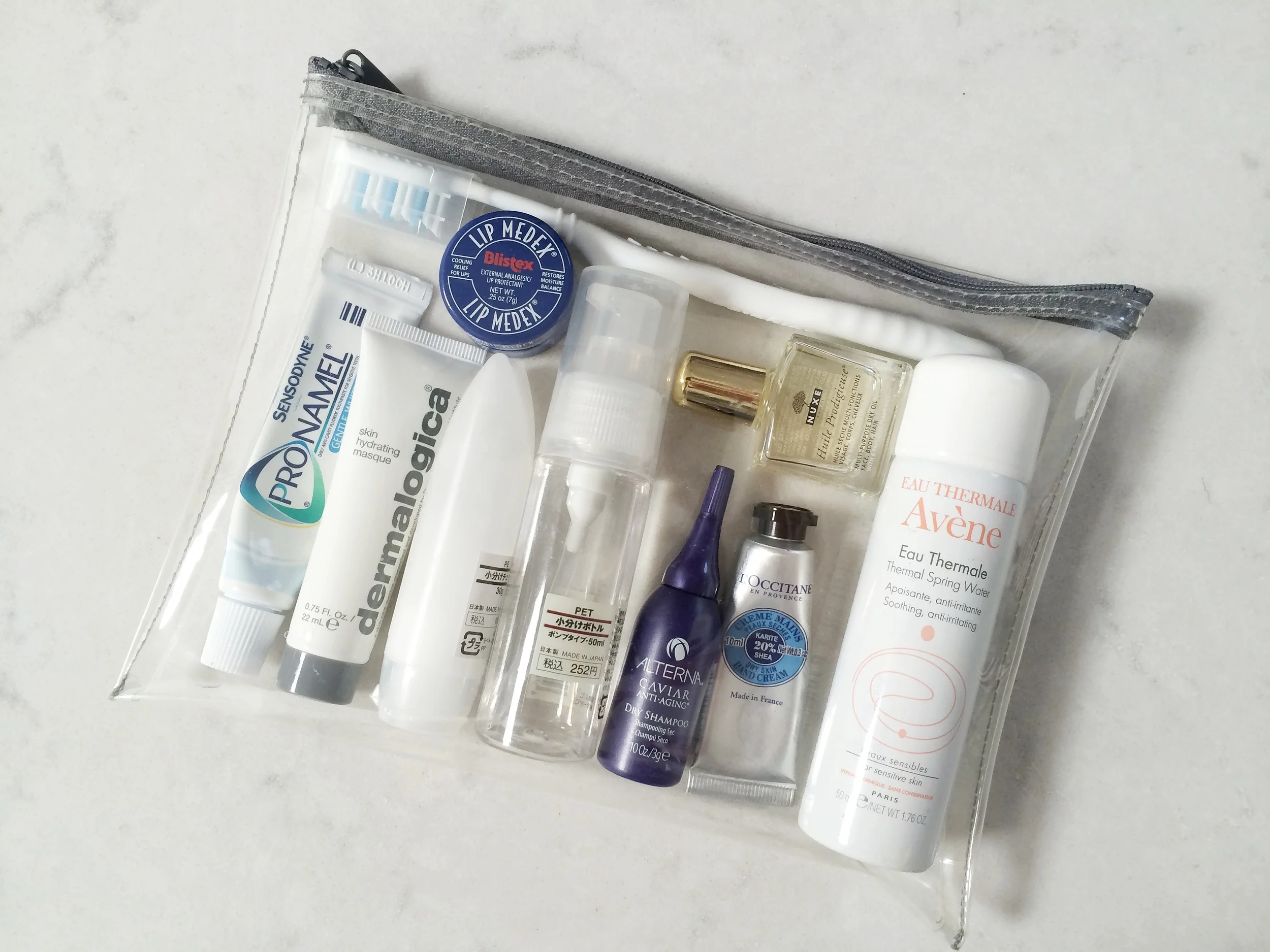 Dental hygiene products, dry shampoo, avene facial spray, mini loccitane hand cream, lip balm, facial moisturizer & bioderma in muji bottles, Dermalogical hydrating mask, and Nuxe Dry Oil (for hair and body)