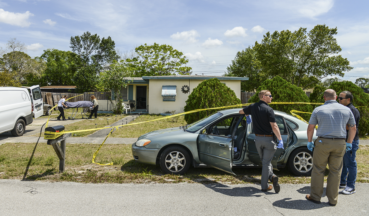  Volusia County Sheriff’s Office detectives Jarett Wooleyhan, Shon McGuire and Miguel Roman prepare to search the vehicle of a woman, Jenna Miller, believed to have died of a heroin overdose. In the background, medical examiners remove Miller’s body 