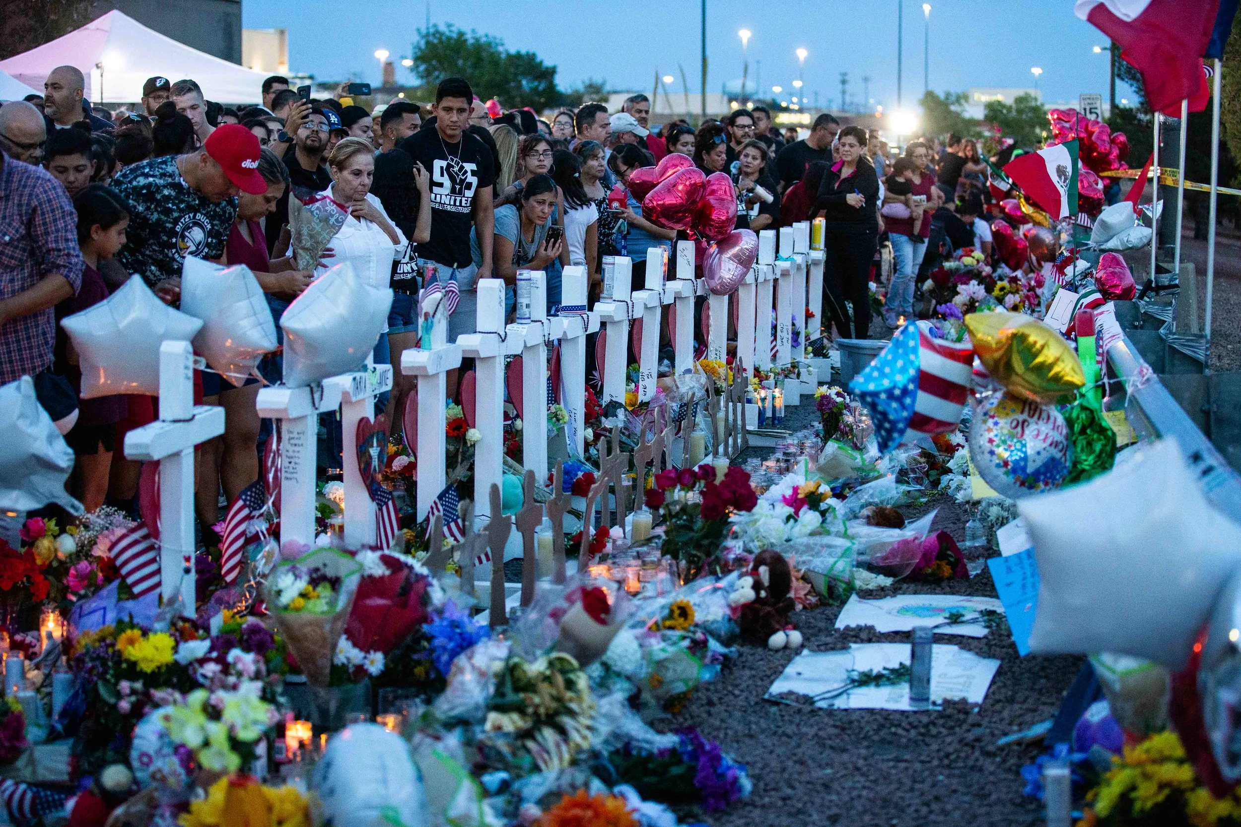 Pleople gather near the scene where crosses with the names of the victims of the mass shooting occurred in Walmart last Saturday morning have been placed to honor their memory in El Paso on Monday, August 5, 2019.