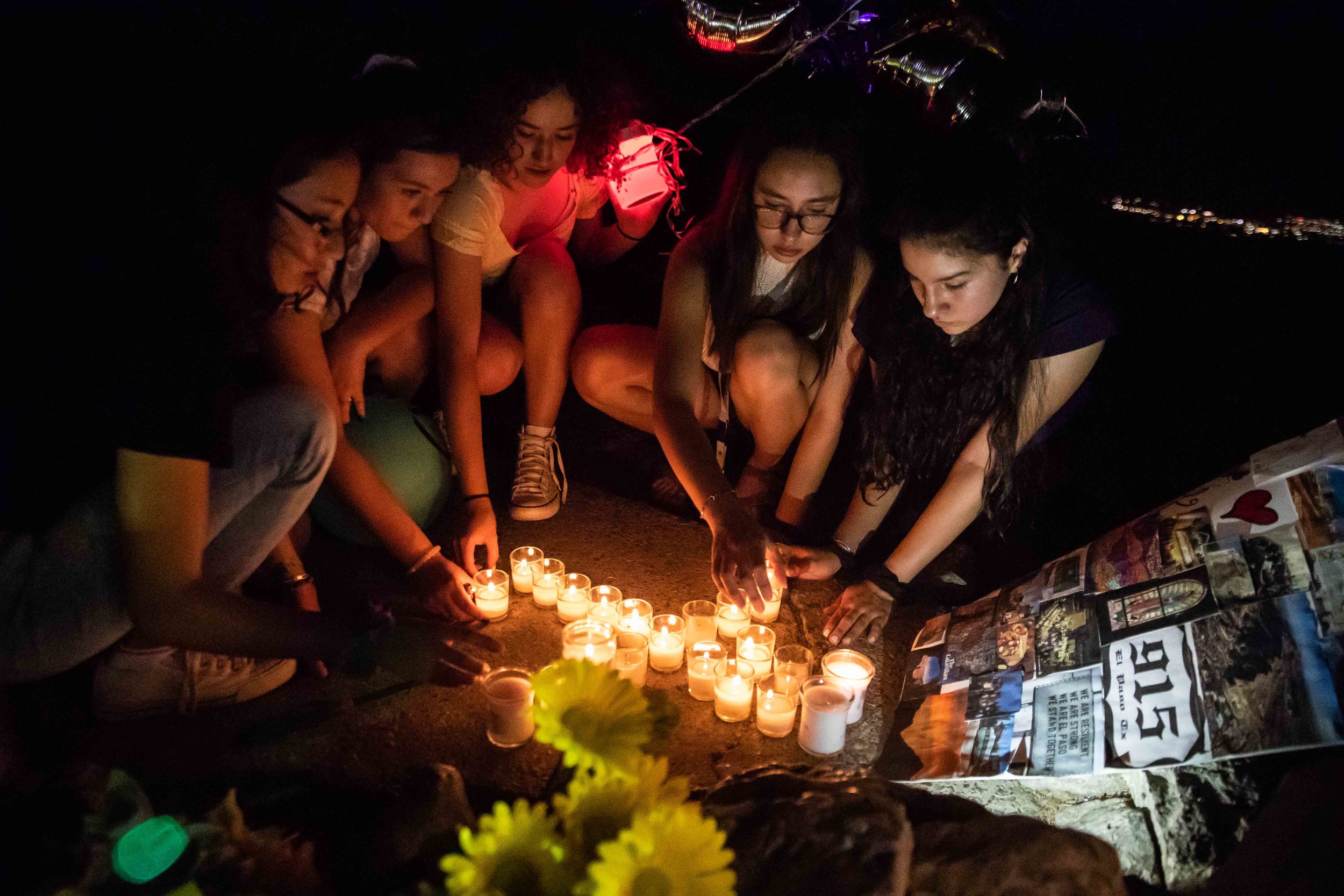  From left, Amanda Torres, Andrea Carrasco, Alexa Carrasco, Chloe Trujillo and Britney Martinez light candles at the Scenic Drive - Overlook to honor the victims of the mass shooting occurred in Walmart last Saturday monirng in El Paso on Monday, Aug