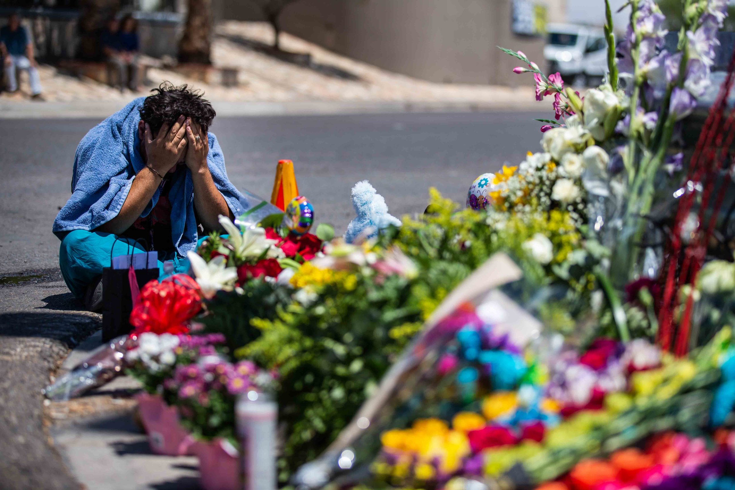  Felipe Avila puts his head in his hands as he cries at the place where the locals bring flowers, stuffed animals, candels and posters to honor the memory of the victims of the mass shooting occurred in Walmart on Saturday morning in El Paso on Sunda