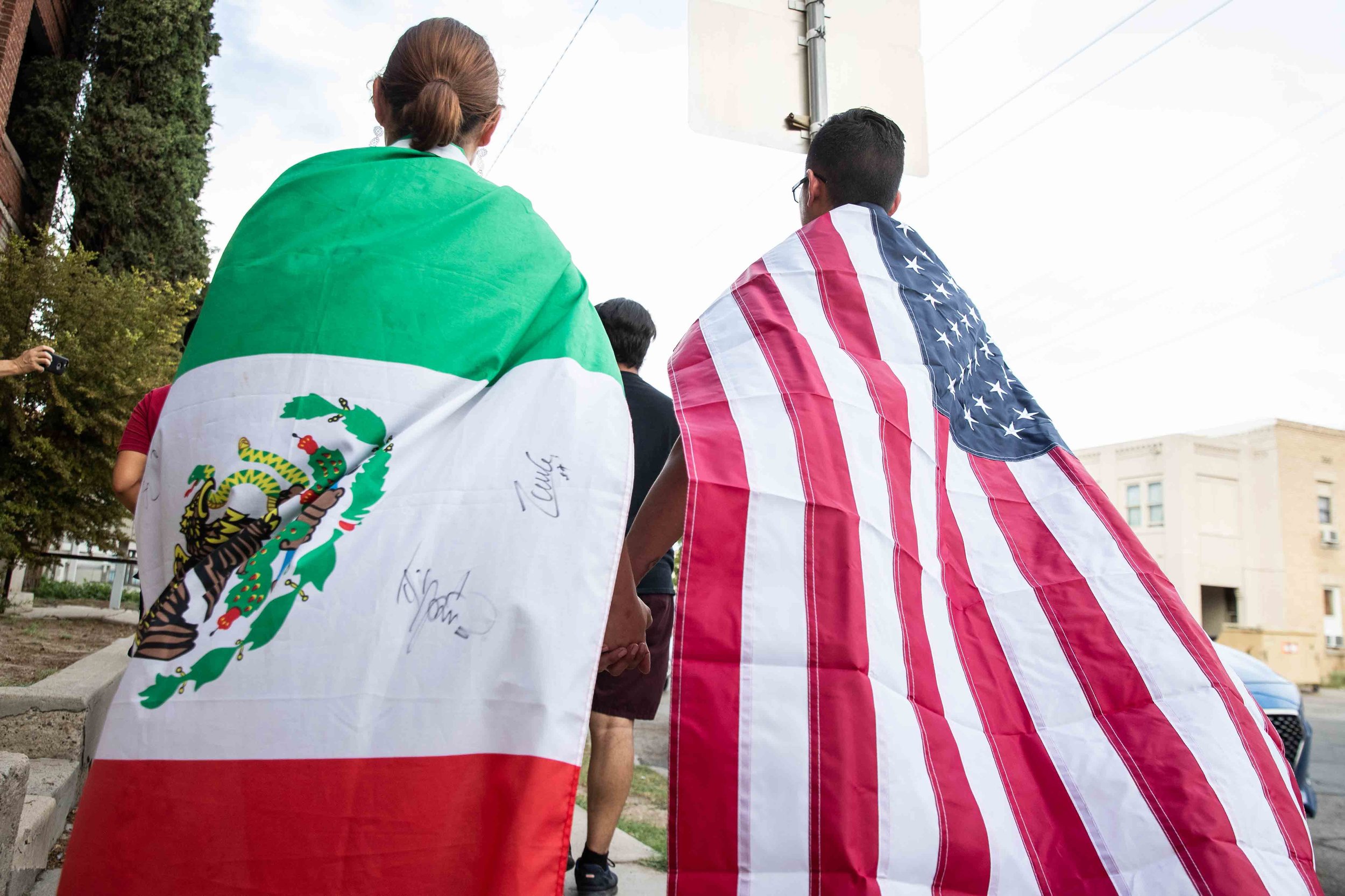  Samantha Ordaz (left) and Cesar Antonio Pacheco (right) carry the flags of Mexico and the United States as they walk holding hands during a silent march in honor to the victims of a mass shooting occurred in Walmart on Satuday morning in El Paso on 