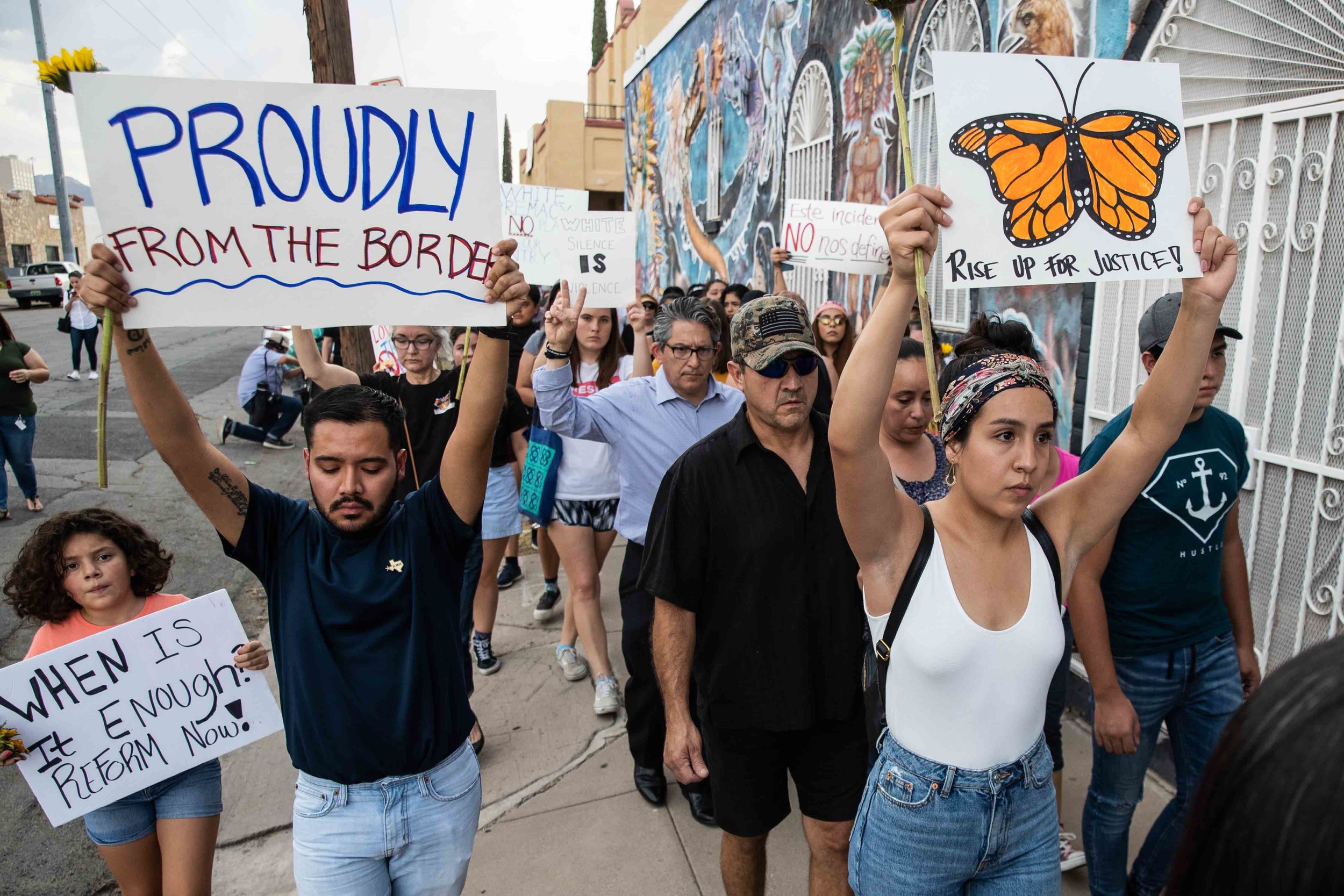  People march in silence holding sunflowers and sings in honor to the victims of a mass shooting occurred in Walmart on Satuday morning in El Paso on Sunday, August 4, 2019. 