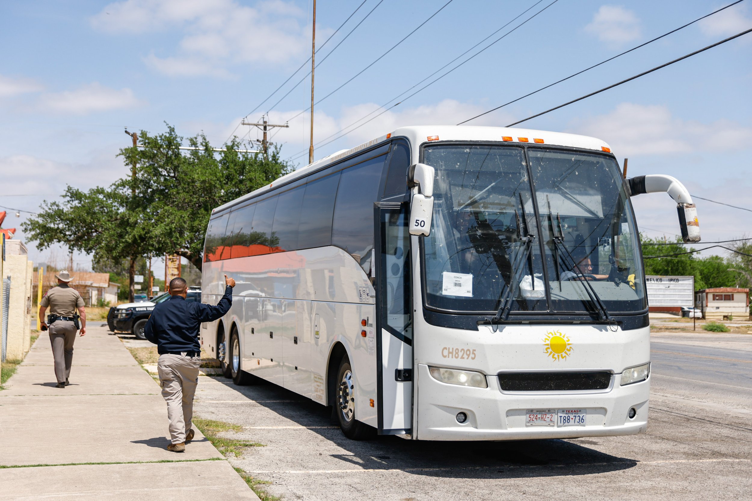  A Texas Emergency Management officer gives a thumbs up to the bus driver after boarding a group of migrants on the bus bound for the East coast as part of those who are using the service offered by Governor Greg Abbott for undocumented migrants who 