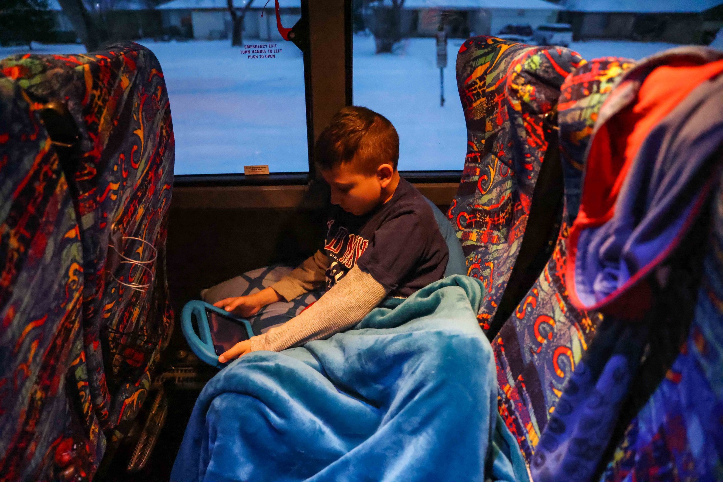  Aaron Hall, 11, who is on the spectrum, checks his tablet as he prepares to spend the second consecutive night along with her mother Marleny Almendarez, 38, at the bus that serves as a warming center located in Pleasant Oaks Recreation Center in Dal