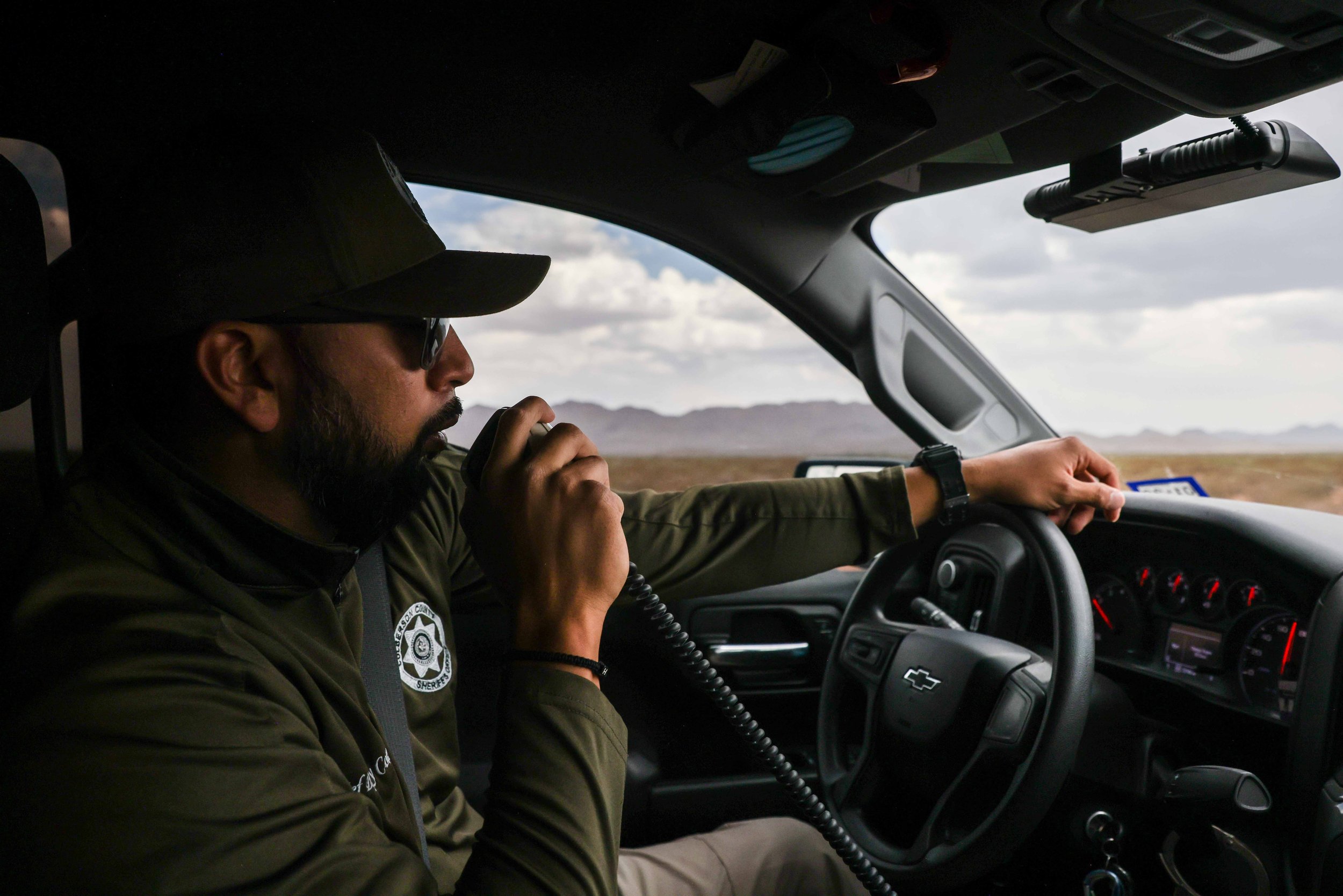  Culberson County Chief Deputy Joseph Corrales speaks through the radio dispatch unit in his truck as he drives through the mountains where undocumented migrants usually walk after crossing the border from Mexico to the United States, through Culbers