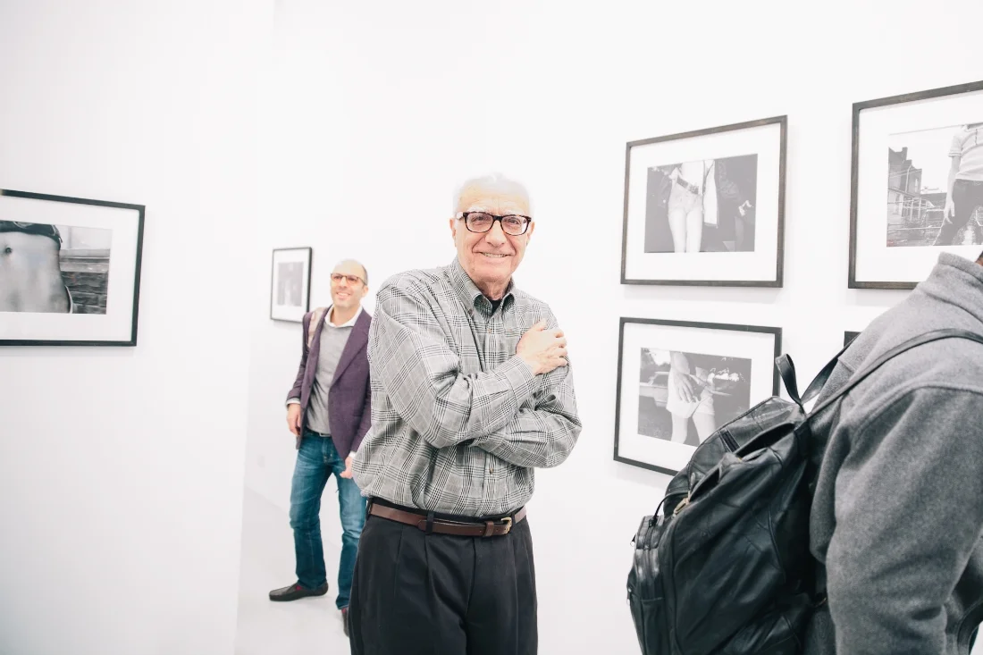 Mark Cohen, the artist, at his show May 10th. Ivan Shaw of Vogue in the background.