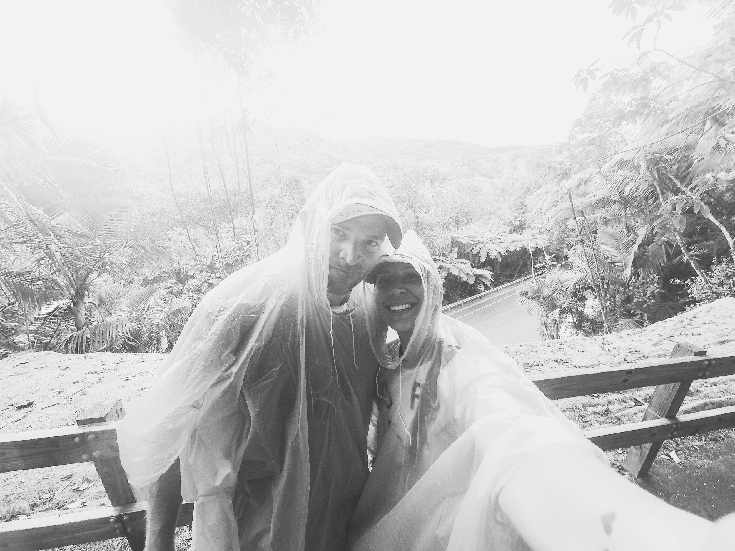 Ok, so if you ever plan to visit Puerto Rico, El Yunque is a MUST. Before I show you one of the top 5 most exhilarating moments of my life, I figure I should fill you in on the journey to get there. We aren't really "organized bus tour" kinda people. We like to move a little quicker and on our own terms. We heard that if we rented a car and headed to the rainforest ourselves, we could actually cover more ground and see the peak of the forest. (Thanks Pat and Lea!) The regular tours only bring you to the heart of the forest and several of the main waterfalls, but that wasn't enough to feed our adventurous appetites. So we rented a car for the day (cheap and easy.) When I pictured hiking through the rainforest, for some reason I didn't think it would actually rain. (why, I'm not sure, the word RAIN is in fact, in rainforest. der. ) But anyways, instinct told me to stop at a store to pick up some ponchos in case it did. This actually turned out to be the best $20 we spent because it rained the ENTIRE 8 hours we were there. If you ever want to test out your relationship, I recommend hiking a mountain through the rainforest for 8 hours in POURING rain. All we could do was just laugh about it and crack jokes the entire time. Now I have known Benny was my soulmate for some time, but this day trip solidified it. He always has an abundance of positive energy in the not-so-nicest of situations. And I love that about him. So up the mountain we drove, until the crowds and tour busses became thinner. We parked the car along 4 other vehicles that were at the trailhead and started our journey up. It was hot, we were sweaty, already in the beginning stages of hangry, and smelled like DEET. (PS- even though PR was a Zika virus flagged country, there are apparently no mosquitos in the rain forest... too many birds/bats outnumber and eat them!) We continued on foot, through the rain, and took in the lush smells of green plant life and soil... every once in a while coming across a fragrant flower and raging waterfalls. Through peaks of the trees, we could see the descending cliffs as the misty fog threatened to swallowed them whole. It took roughly two (somewhat) intense hours of climbing until we finally reached the top. I asked Ben to walk out onto the peak with me, but he politely declined. Looking back, I'm still not sure why, but I was undeniably compelled to walk out onto this slippery ledge. 1,000 foot drops on either side... wind whipping through my poncho and rain pelting my face. It was in this moment I stretched out my arms, closed my eyes, opened my heart to the universe, and truly felt ALIVE.
