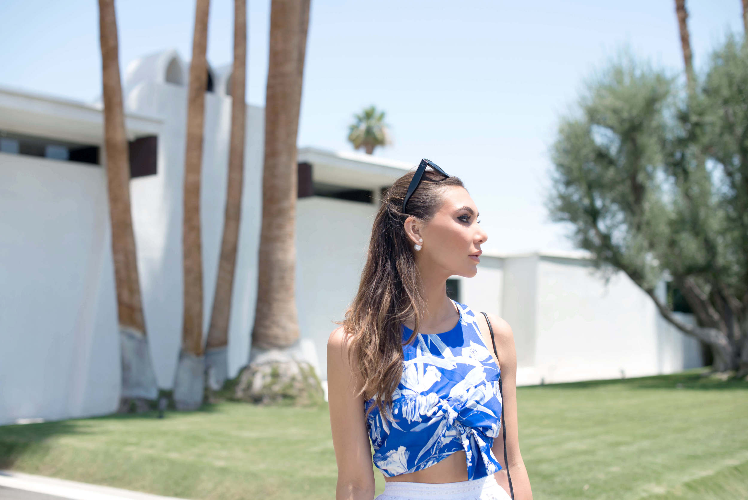 A girl wearing pearl earrings and a floral crop top in Palm Springs