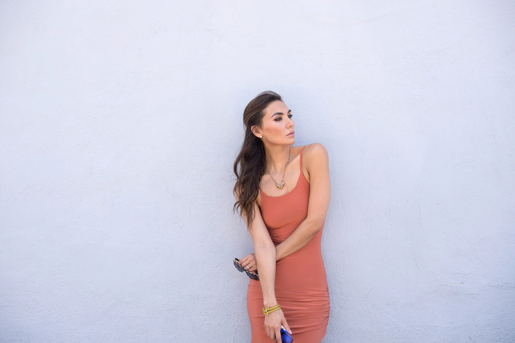 Rust colored body conscious dress and Pamela Love necklace