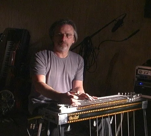 Denny MacMillan - Dobro, Pedal Steel Guitar Denny has been a staple in the local music community since 1967 when he settled in Lawrence from New Jersey. Playing guitar and keyboards through the early 70’s, he found the sound of pedal steel guitar as played by the likes of Jerry Garcia, Peter Kleinow (Sneaky Pete), Buddy Cage (New Riders of the PS), and J.D. Maness. He’s played with many talented local musicians including Arnie Johnson, Johnson Shockly, and Billy Spears. In the mid 80’s to late 90’s, he played the Kansas City club scene and later toured with a “Nashville Hopeful.” Denny is most known in the area for playing dobro with local groups. He currently performs at downtown venues and at special events in the Lawrence/KC area. Besides teaching Pedal Steel and Dobro, Denny teaches guitar in a style known as “Hybrid Picking,” a combination of finger picking and flat picking. Denny will teach you exercises that will help you to interpret what you’re envisioning and say it through scale manipulation and finger picking tricks.
