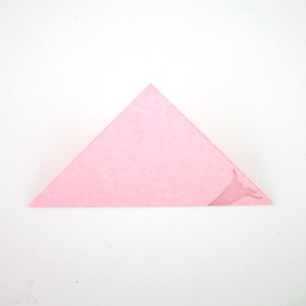 2. Place pretty side down, then fold diagonally to make a triangle.