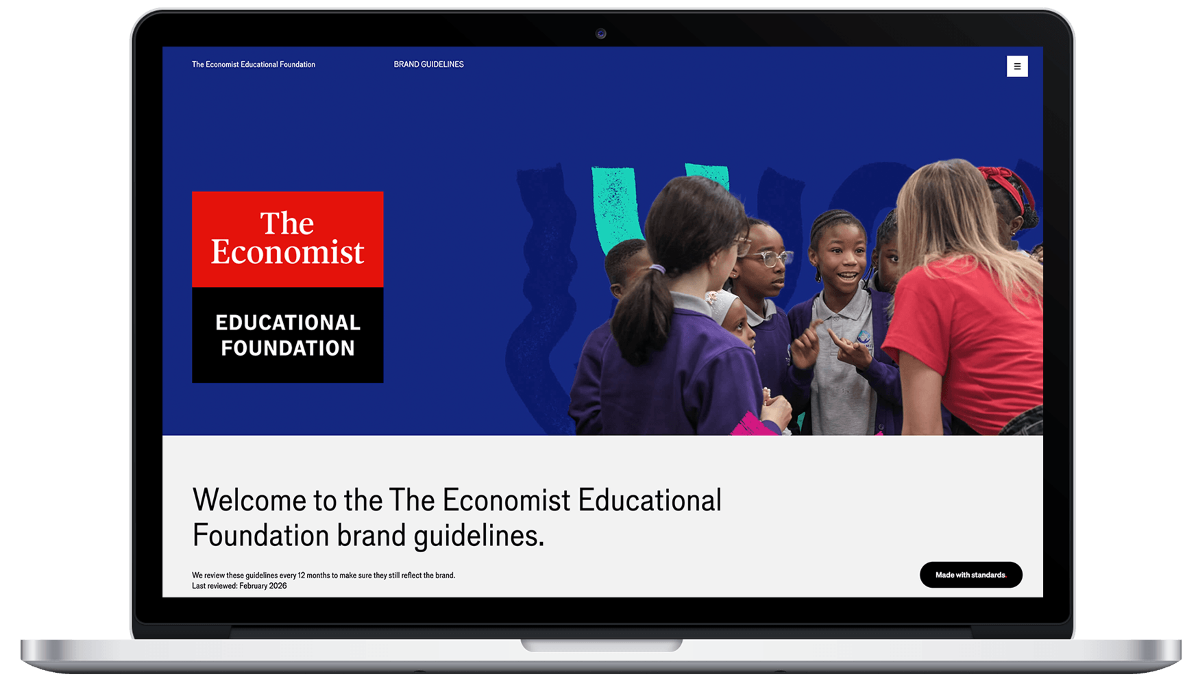 Laptop screen displaying The Economist Educational Foundation brand guidelines webpage with a group of diverse children talking to a woman.