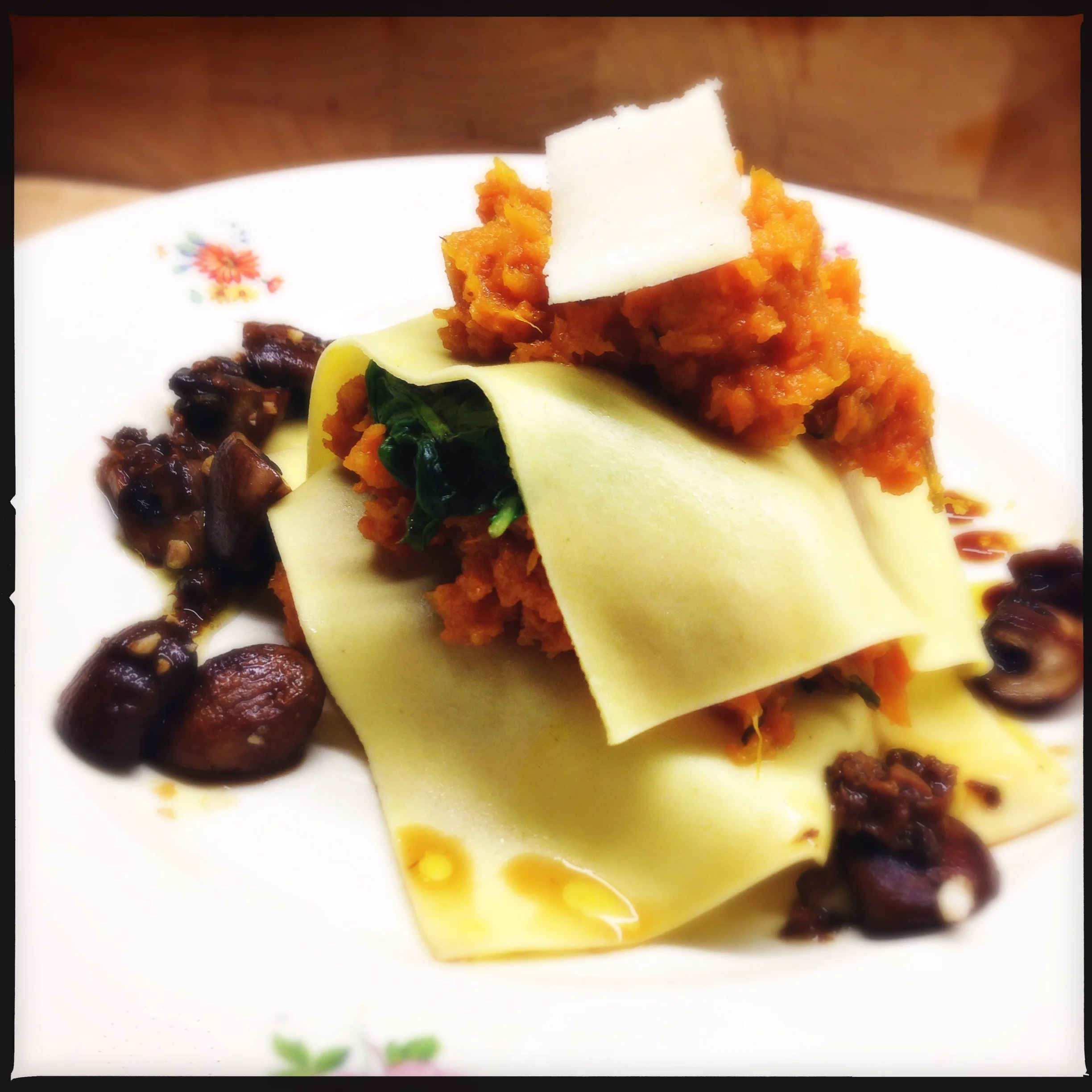 Hoofdgerecht: open ravioli met geroosterde pompoen puree, spinazie en knoflookchampignons Main course: open ravioli with roasted pumpkin puree, spinach and garlic mushrooms.