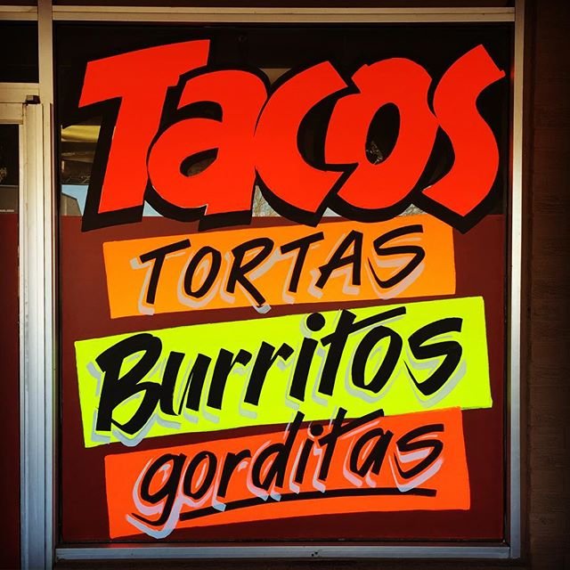 Signboard advertising Mexican food items: tacos, tortillas, burritos, gorditas with colorful, bold lettering.