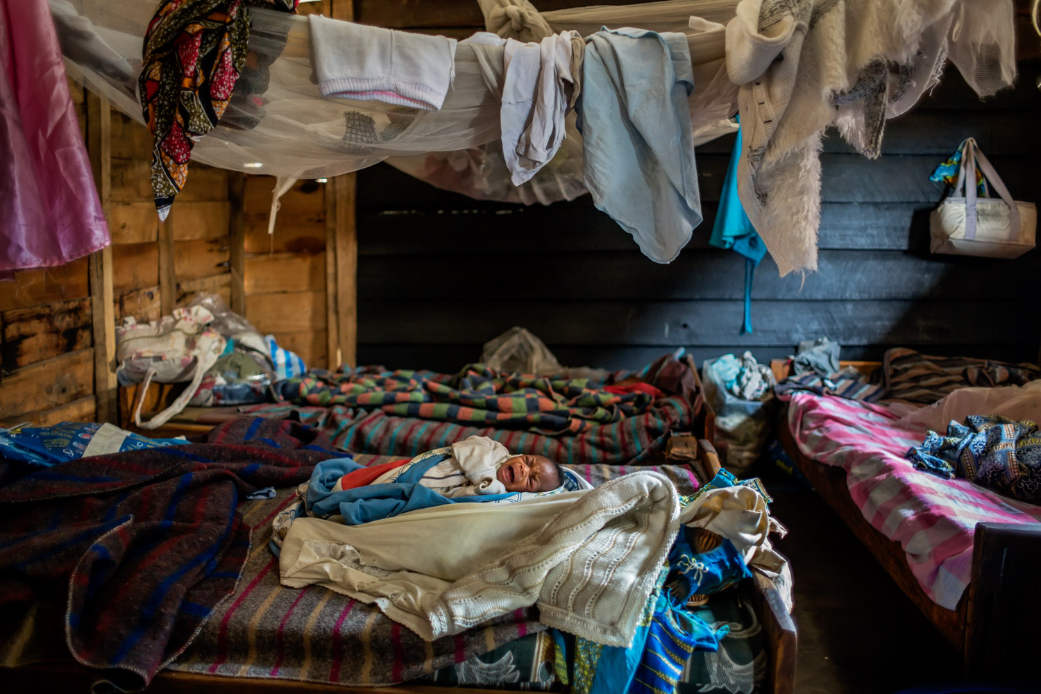  A two-week-old infant cries in a shelter for victims of sexual violence in the village of Buganga, two miles south of Minova. Founded by the activist Rebeca Masika Katsuva, a rape survivor herself, the center was home to more than 30 women and child
