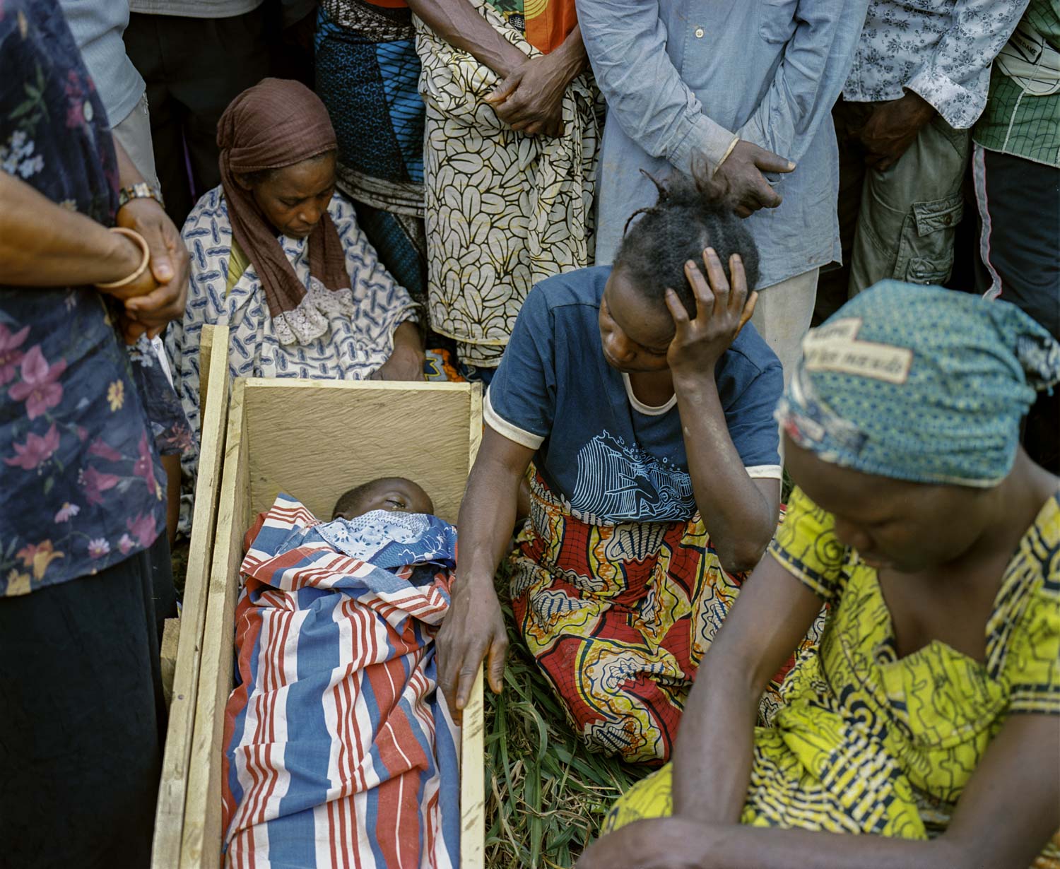  Villagers and family members mourn at the funeral of his murdered 7-year old son, Damas. The belief in sorcery includes a dogma that a rope used to commit suicide has inherent powers; the rope can be sold in markets in Burundi and Tanzania for thous