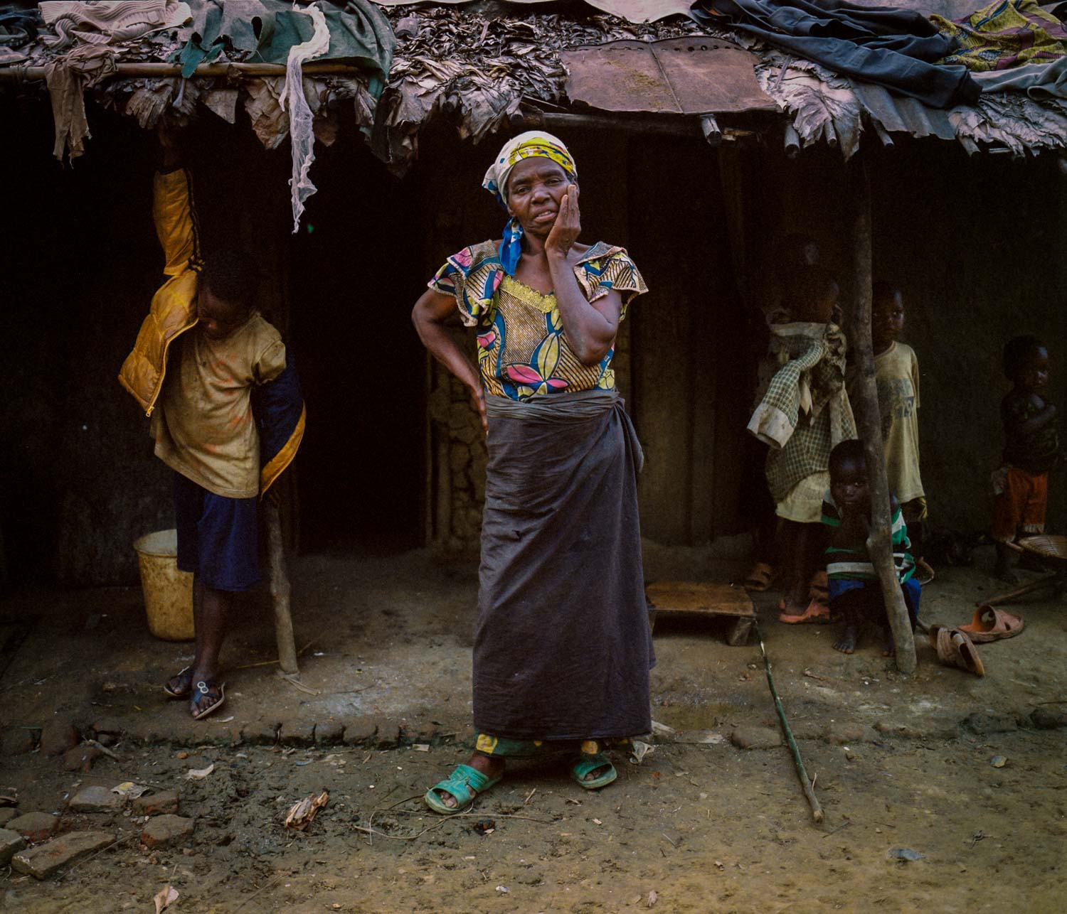  Widow Madelaine Kapinga stands outside of her makeshift home in a part of Lulingu town that is occupied by people displaced by the conflict. Her story is not an uncommon one in the area, where most have lost family to massacres committed by the Inte