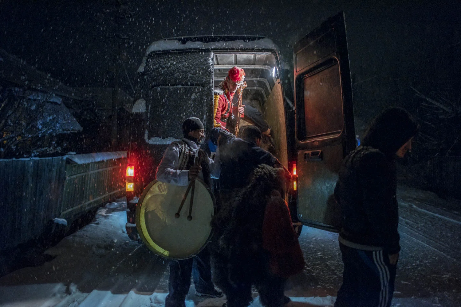 Toloaca's troupe piles into a van that will take them to the next village. In the days leading up to the New Year, troupes of bears dance their way into the night through a handful of towns and villages in the Trotuș Valley. December 28, 2014. Asău village, Bacău County, Romania.Asău village, Bacău County, Romania.