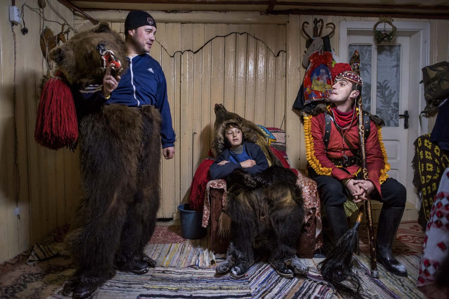  Cătălin Apetroaie chats on his porch with a young bear and Gabriel Hanganu, the 'bear tamer.'  The troupe, led by Dumitru Toloaca, has just finished performing for Apetroaie's family and are resting before they continue on to the homes of other patr