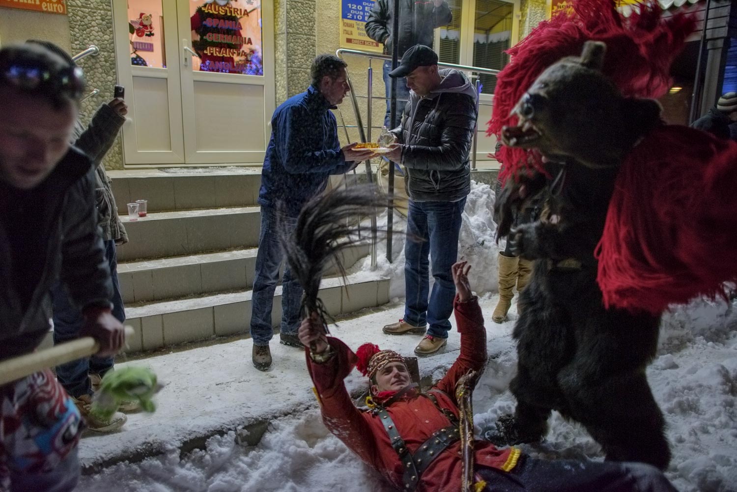  After winning first place at Comăneşti's annual Bear Parade, Toloacă's troupe celebrates in the streets, singing, dancing, and toasting with homemade palinka liquor handed out by the locals. December 30, 2014. Comăneşti town, Bacău county, Romania. 
