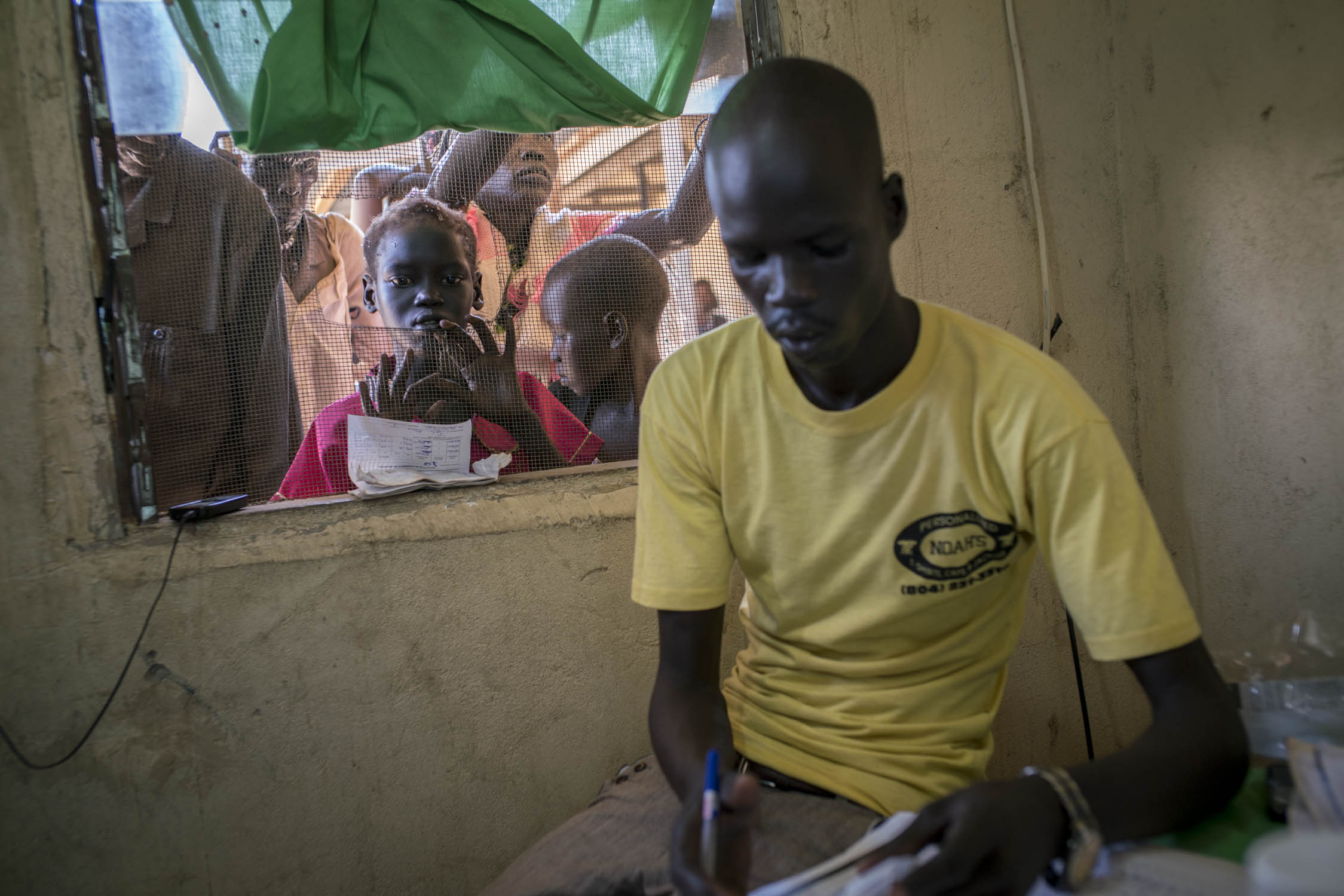  Patients wait to receive medicine at a health care center in Panthou village. Located in a remote rural area, the center was the only place in Aweil South county where patients might be able to receive free treatment and medicine for malaria. Only t