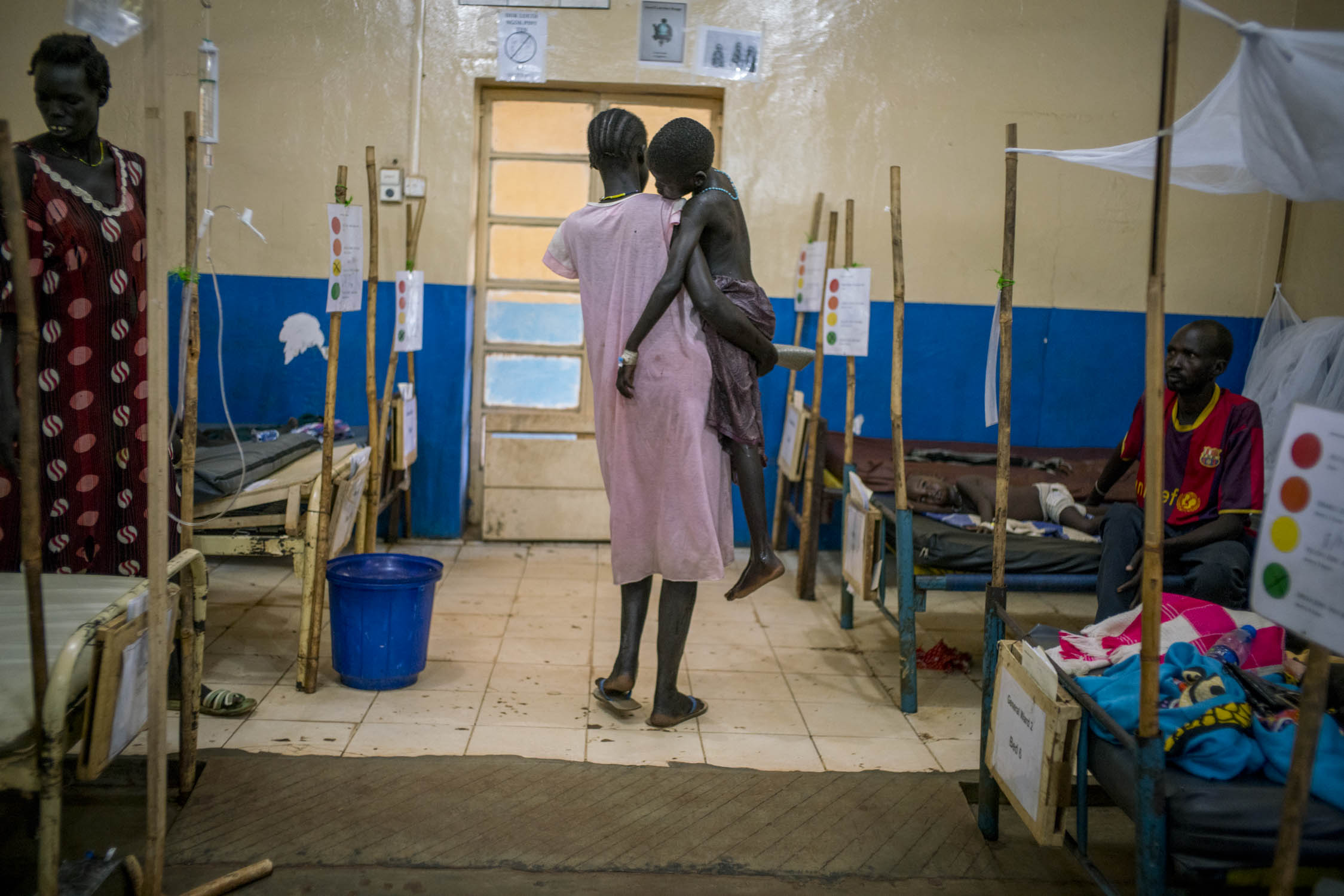  Aweng Diing Geng, 5, is carried back to her bed by her mother, who has just finished bathing her in the yard of the MSF hospital in Aweil, the main city in South Sudan's poorest state,&nbsp;Northern Bahr el Ghazal. Aweng is receiving treatment for s