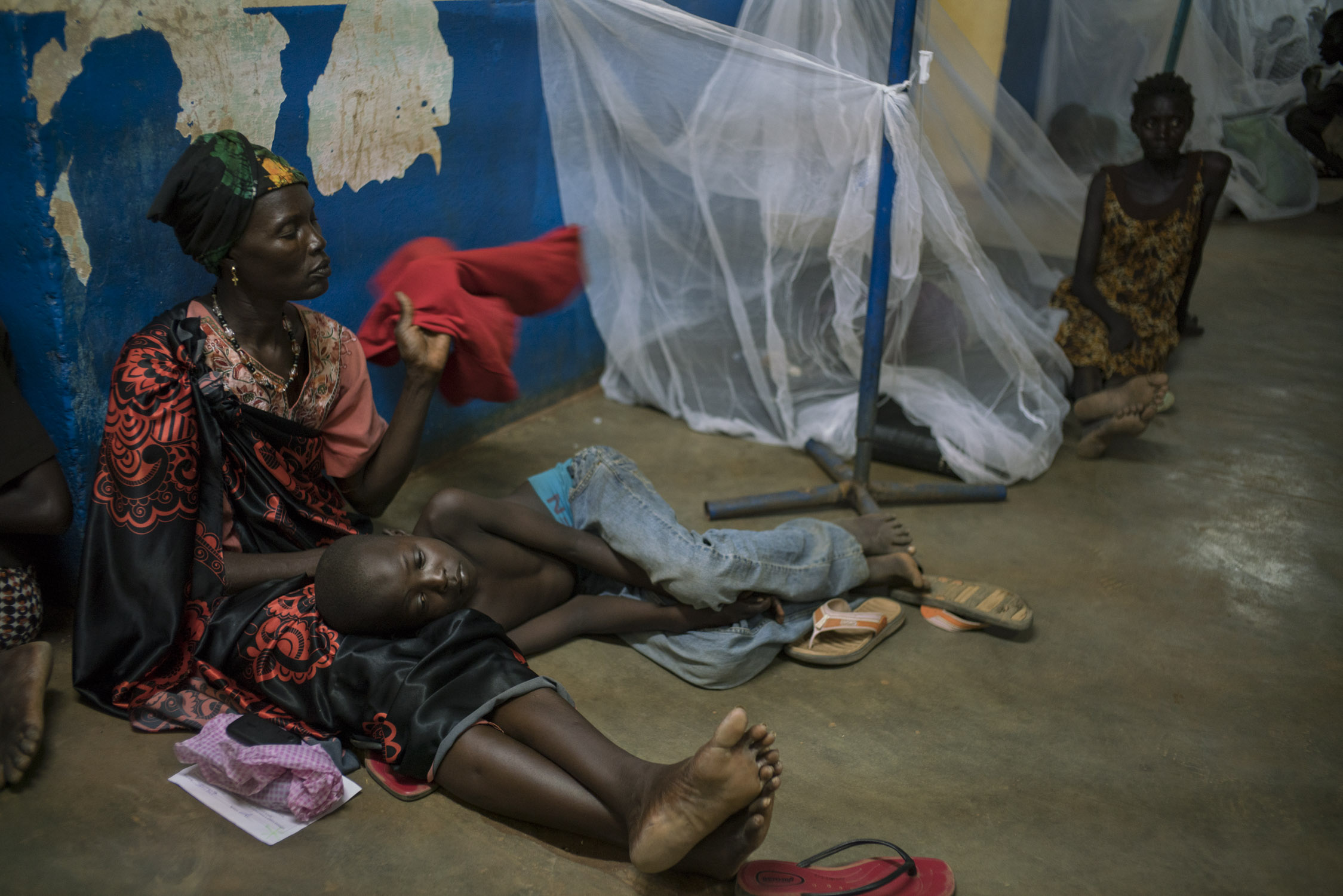  A woman fans her feverish son, and waits for him to be admitted into the MSF-run portion of the hospital in Aweil, the only hospital serving the 1.2 million living in Northern Bahr el Ghazal, South Sudan's poorest state. An overflow of malaria patie