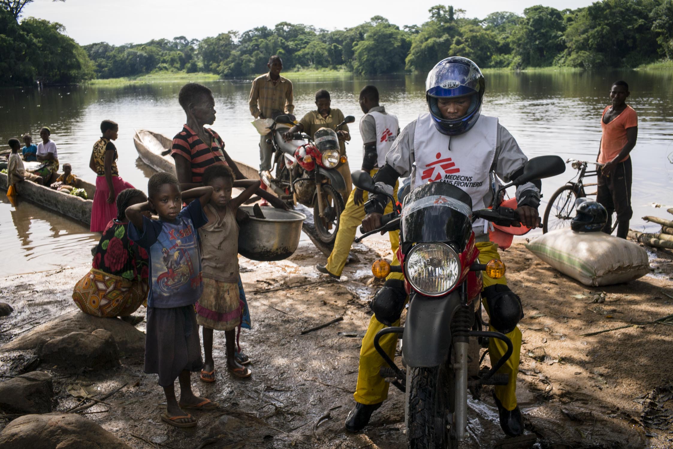  MSF drivers disembark their motorcycles from the local  pirogues  (traditional canoes)&nbsp;used to cross a river on their journey to a health center in Sombe, a village in the remote Bas-Uele province of Democratic Republic of the Congo (DRC). MSF 