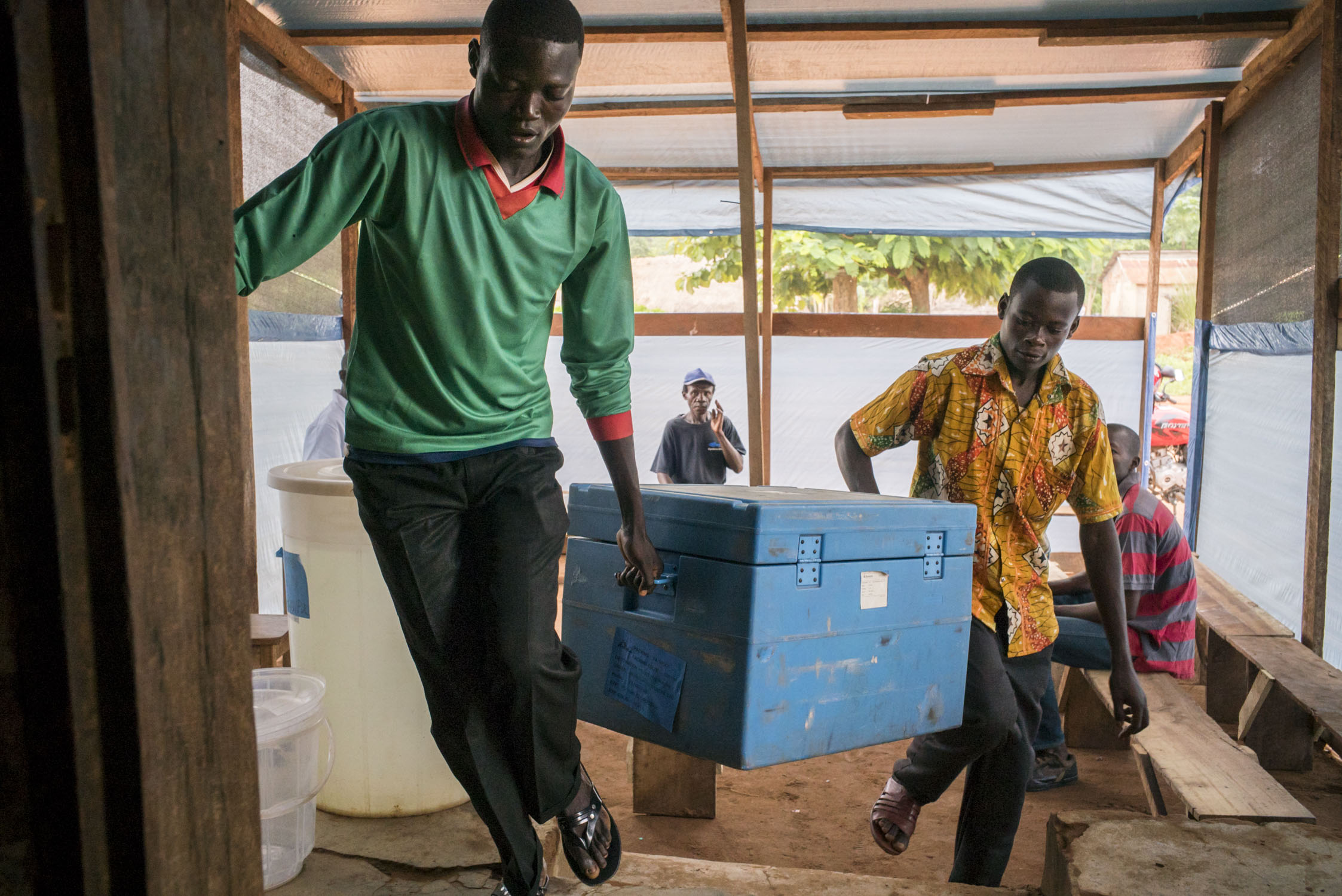  Local health workers carry in a cooler with vaccines into a health center in Monga, a town in a remote region of northern Democratic Republic of the Congo (DRC). The vaccines are to be administered the following day, as part of a 5-day measles vacci