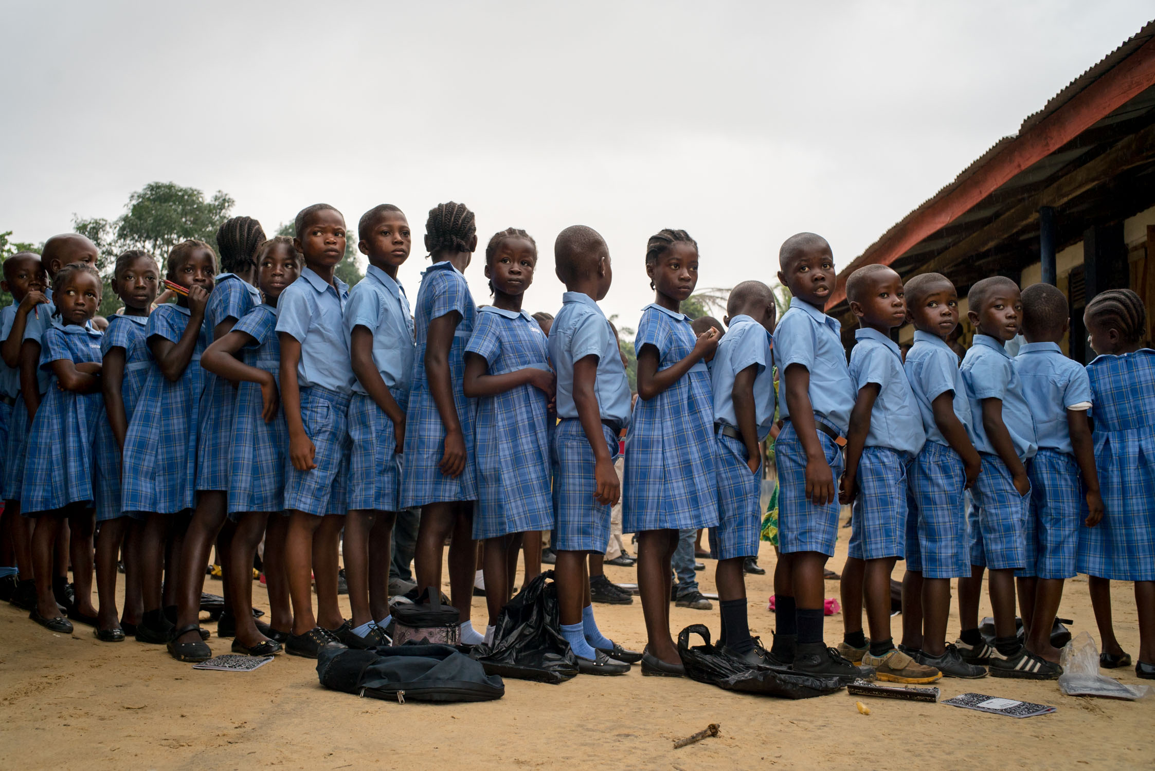  Children line up in the hallway of a recently opened Bridge school in TK Plantation, a rural community outside of Monrovia. September 23, 2016. TK Plantation, Monrovia, Liberia. 
