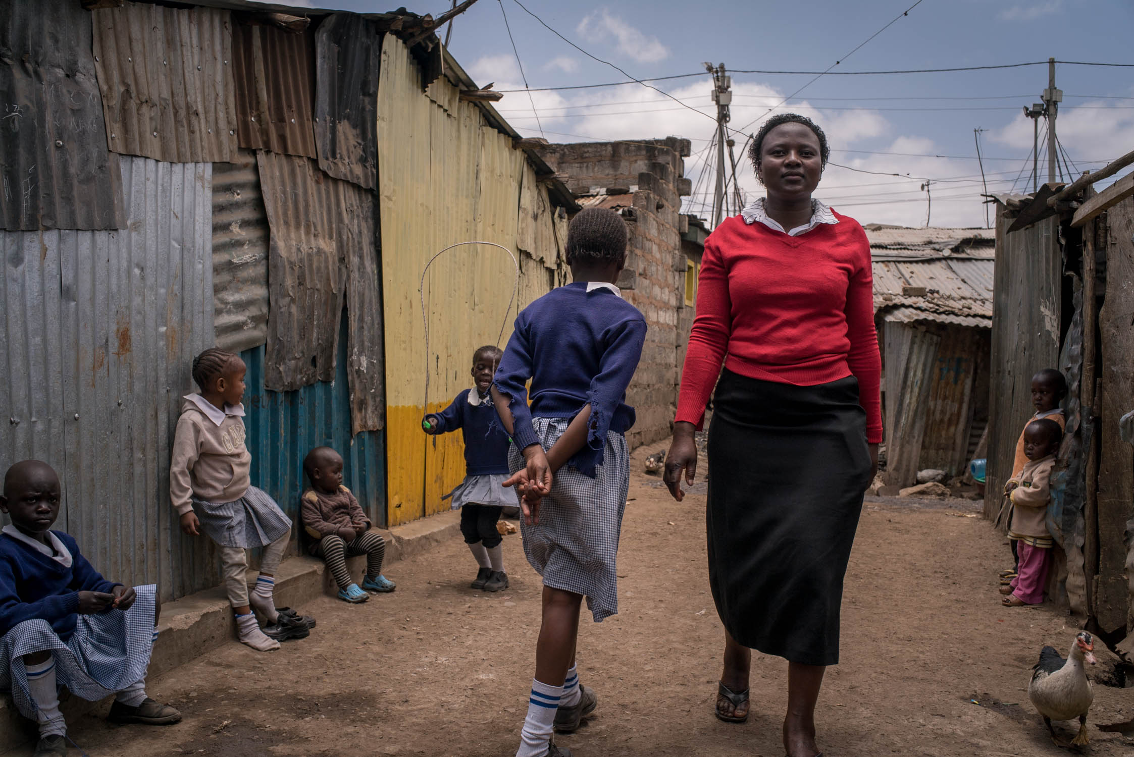  A teacher walks past children at a school (not Bridge) in Mathare slum area of Nairobi. September 19, 2016. Mathare slum, Nairobi, Kenya.&nbsp; 
