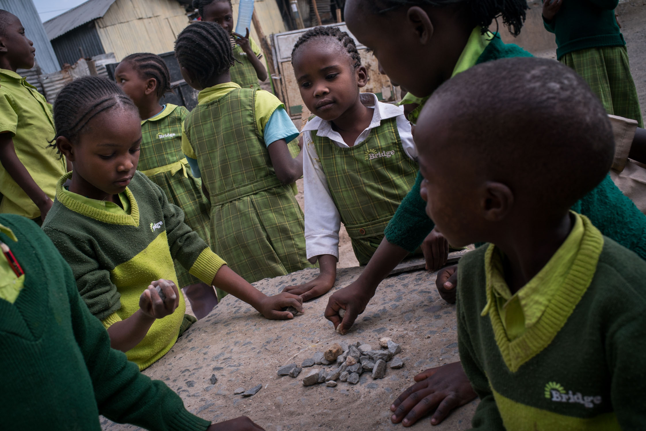  Students with small stones in the yard of a Bridge school in Mukuru slum. September 20, 2016. Mukuru, Nairobi, Kenya.&nbsp; 