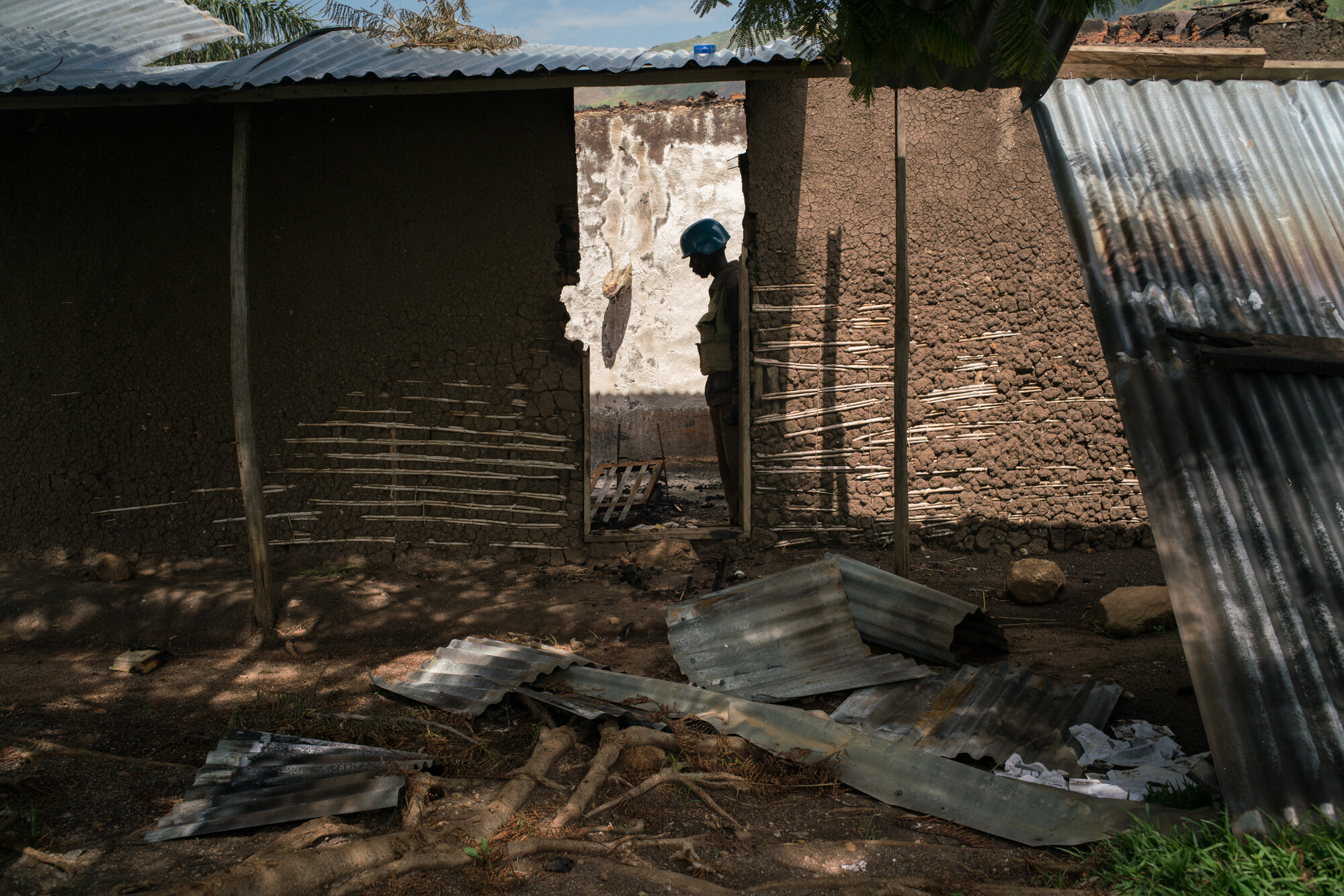  Basima Bovias Nyau, 41, the chief of Dii surveys the scortched ruins of what was once the health clinic in his mountaintop village, attacked on March 13, just after the attacks on the previous day in the villages at the foot of the mountain, along t