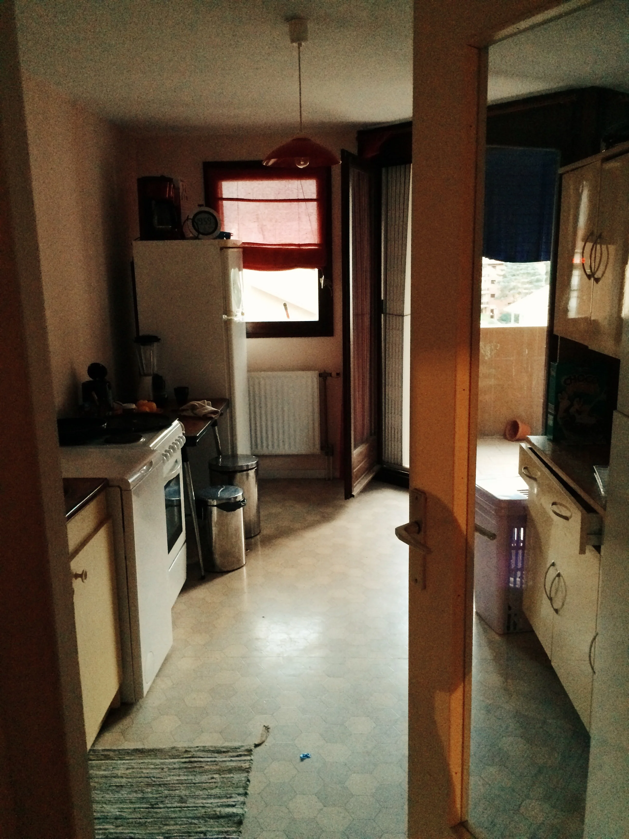 The kitchen, which opens up to the balcony, and also includes a washer, stove, and oven.