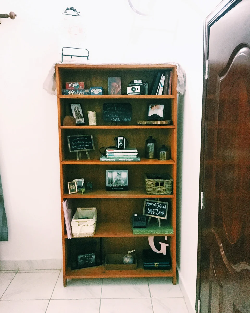 One of my favorite things about our house is this bookshelf. Another buy off a family who was moving and we were lucky enough to get to send a ton of our stuff over on a container. So I packed those plastic buckets full of memories. The decor has been rearranged quite a bit over the years and of course we’ve added a few things, but this is the general idea. It contains our wedding photo book, our wedding guest book, things people made for us for our wedding, and of course photos and some of our favorite coffee table books. I’m still debating on whether or not I want to eventually paint this thing white, but the wood on it is much prettier than a lot of our other pieces so it will probably depend on if I have any paint left. (I bought a paint off of Amazon that’s similar to chalk paint, so no sanding required. I did not bring this in a suitcase so I’m not sure what the rule is on that, I was able to get it over on a container, but I’ll link it below too)