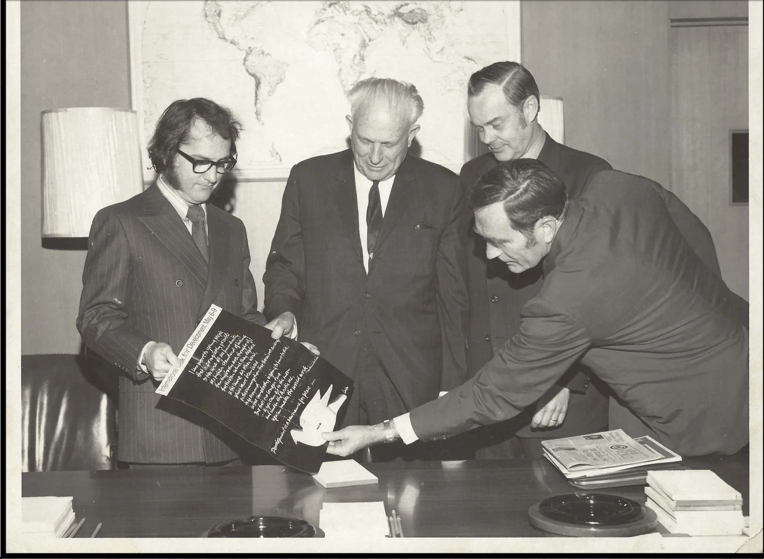 Agency for International Development welcomes the leadership of Young World Development while admiring Sister Corita's artwork. From left: Jack Healey, Mr. Brown and Mr. Hedges.
