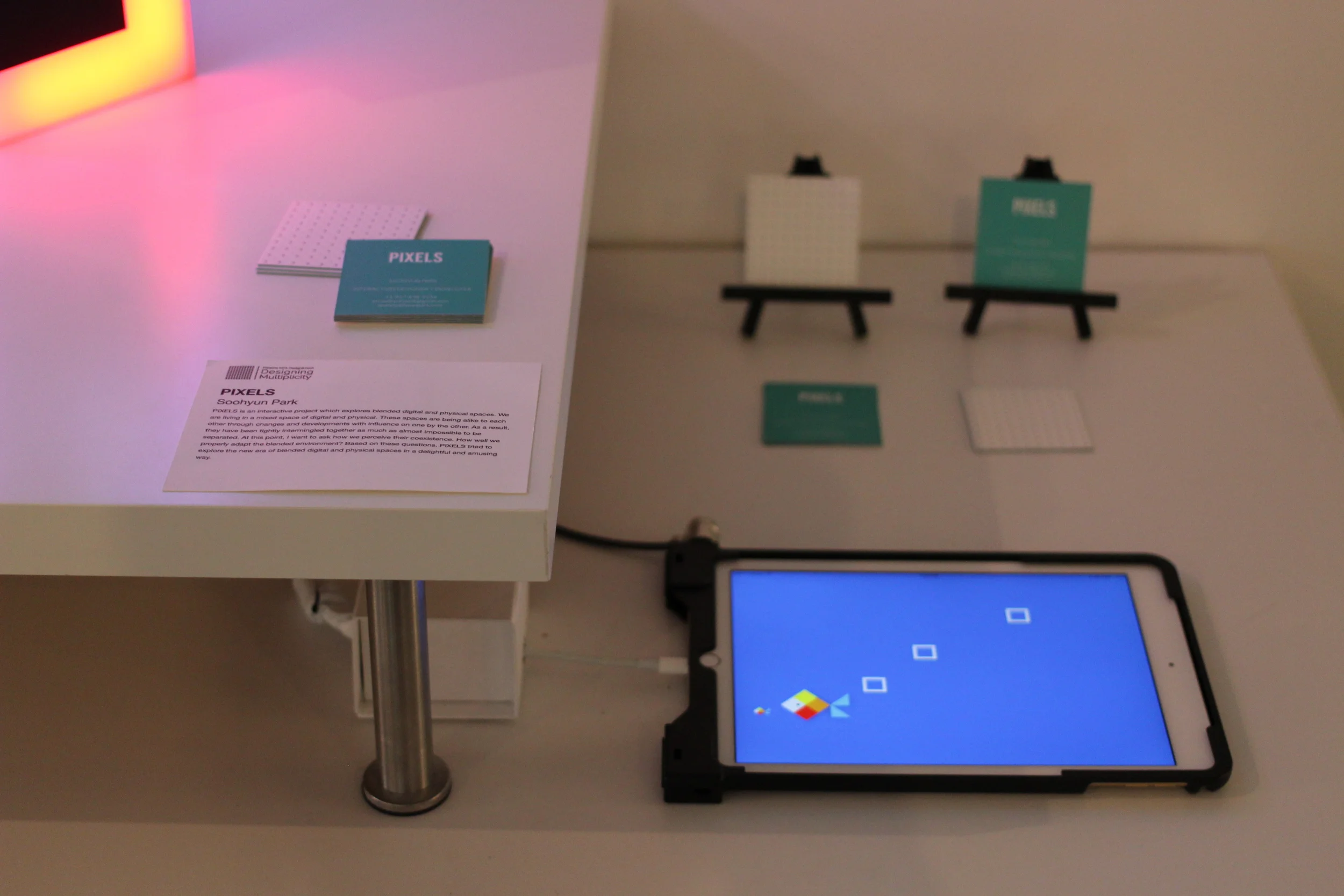 Users can connect to up to 4 PIXELS objects with the app "PIXELS" and see multiple square box appears on the screen. Each one box correlates to specific connected object and show the same color of pixel. UX Example 01 : (single user) play with dragging boxes on the screen to catch the fishes. challenging to change the color of light object as much as they can. UX Example 02 : (multiple u ser) a person drags the boxes on the screen and place the boxes in certain order or shape. the other person challenges to find out which PIXELS object connected to which white box on the screen and place the object in a same order of shape that the other made.