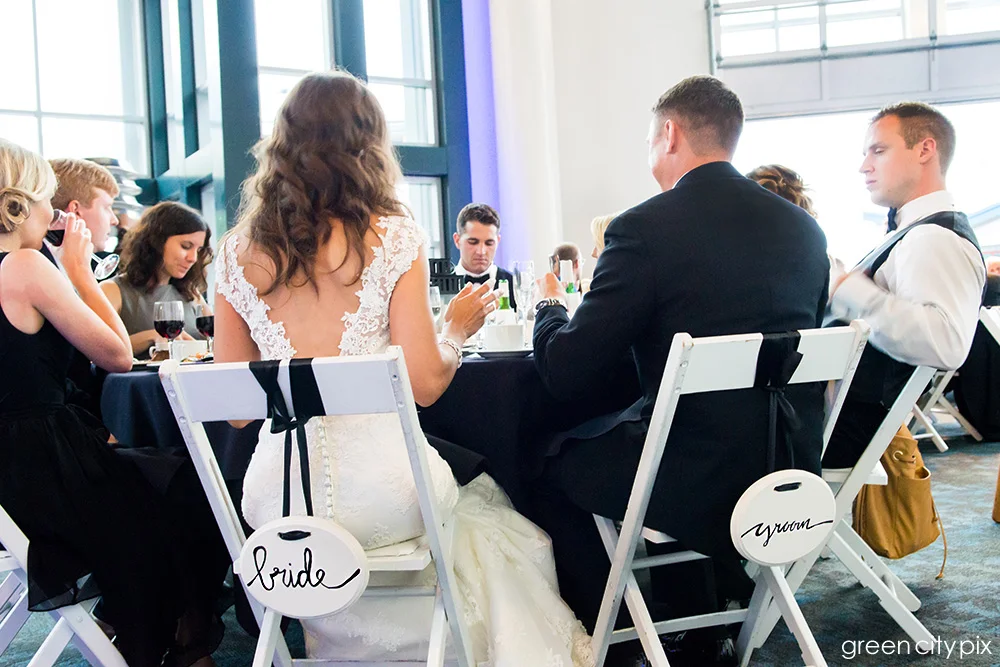 Baby got back: I love the open V-back on Annie's dress, and the cute bride and groom signs on their chairs.